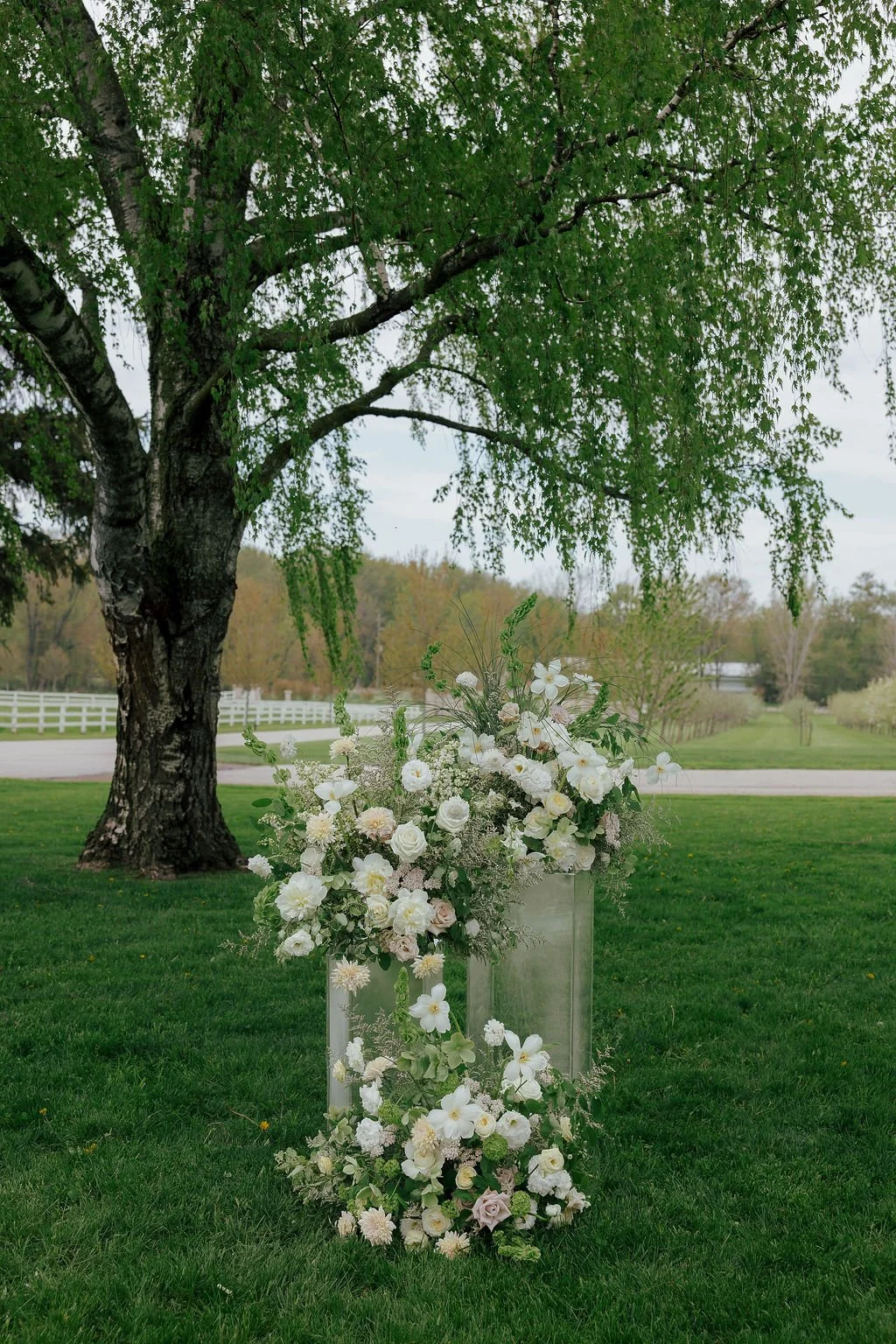 White wedding flowers on acrylic pillars