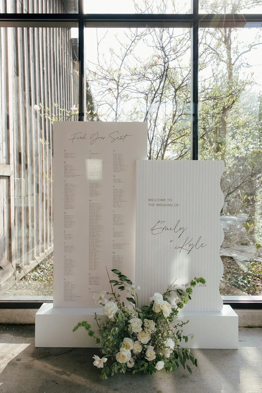 Wavy edge wedding welcome sign and seating chart with white floral meadow