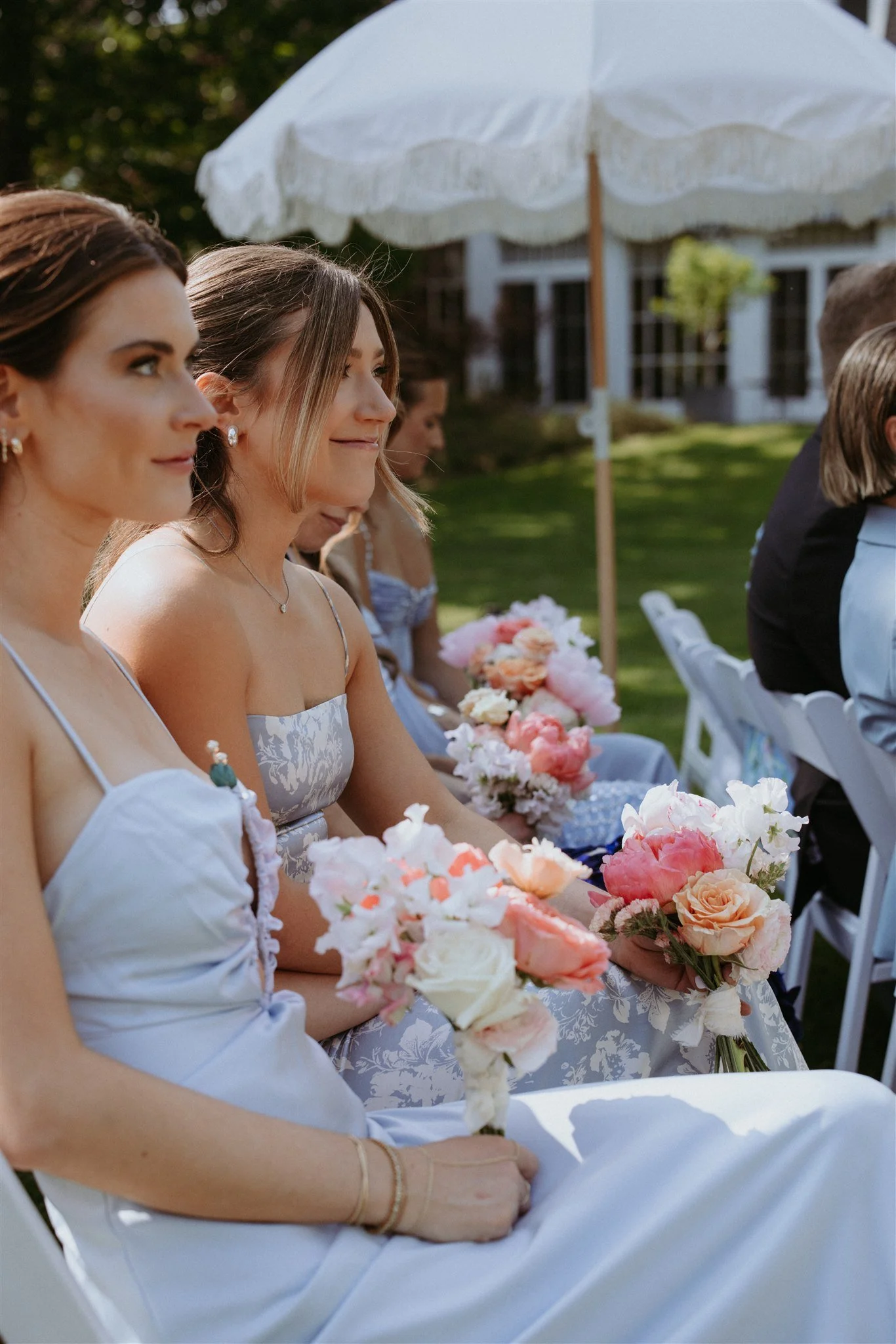 Bridesmaids watching ceremony and holding bouquets by Wild Vogel Works