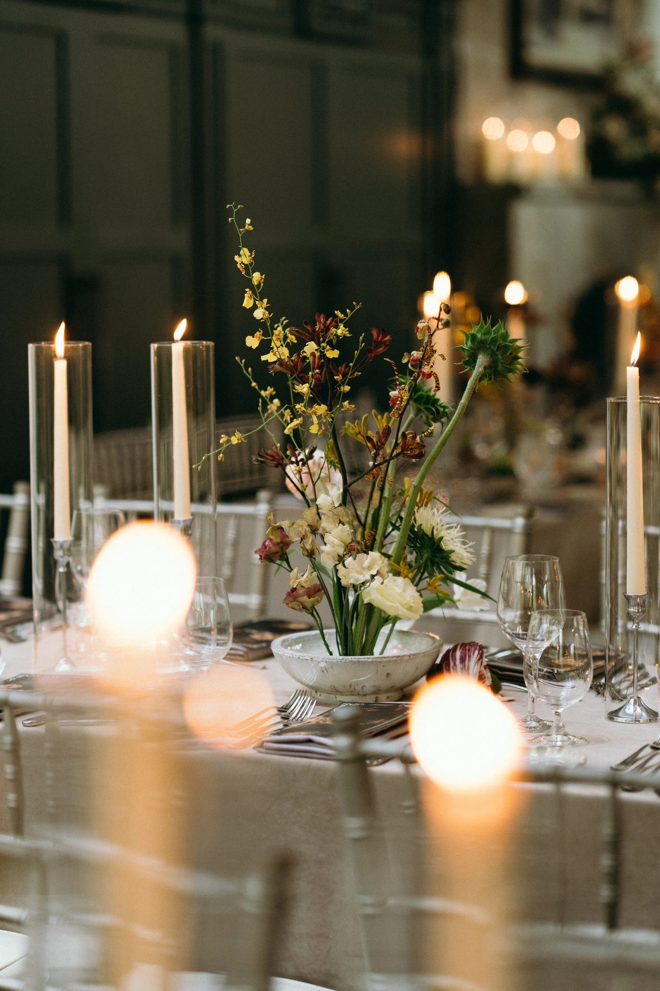 Ikebana arrangement with yellow and burgundy flowers