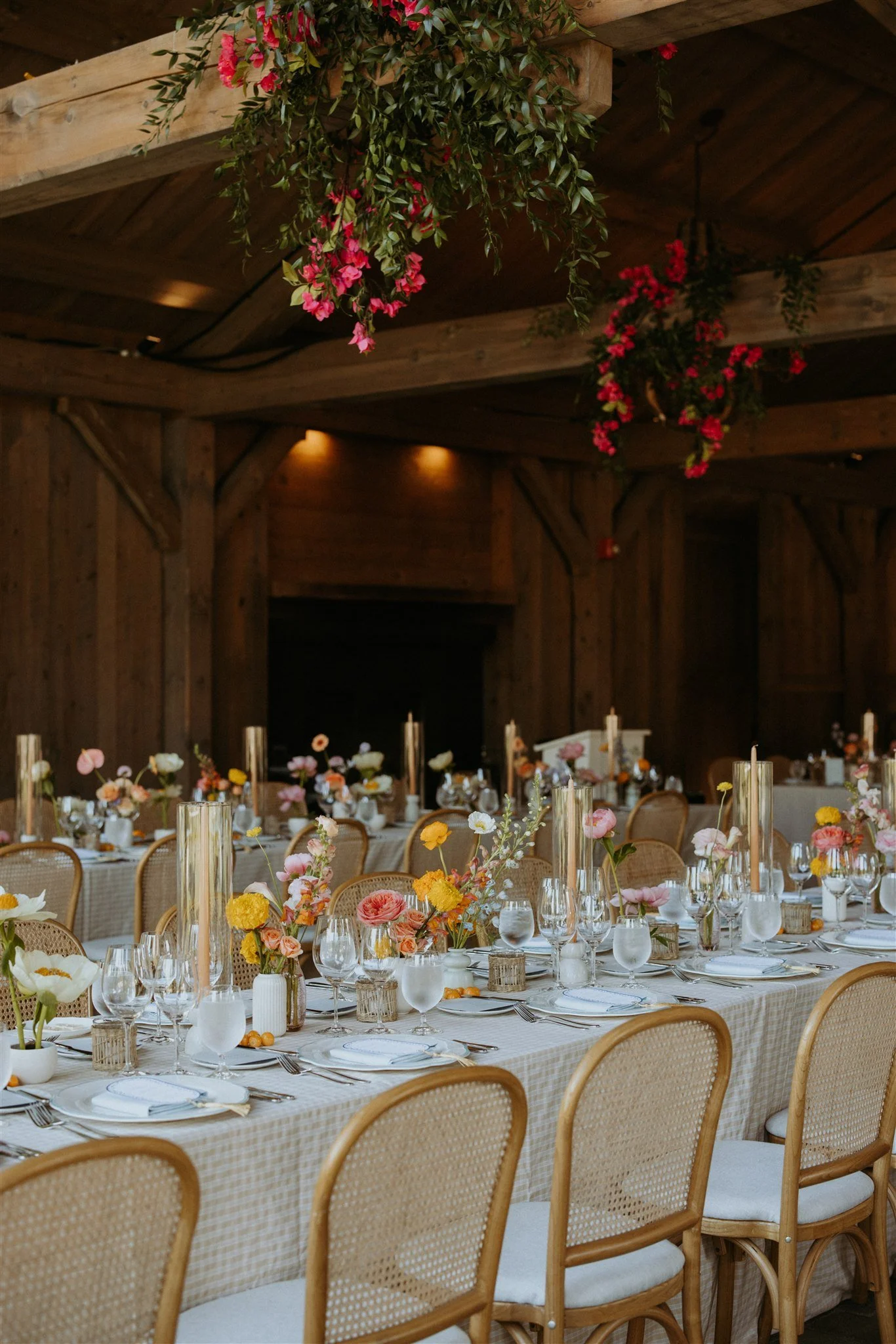 Wedding tablescape with oatmeal check linen, colorful florals, and rattan chairs