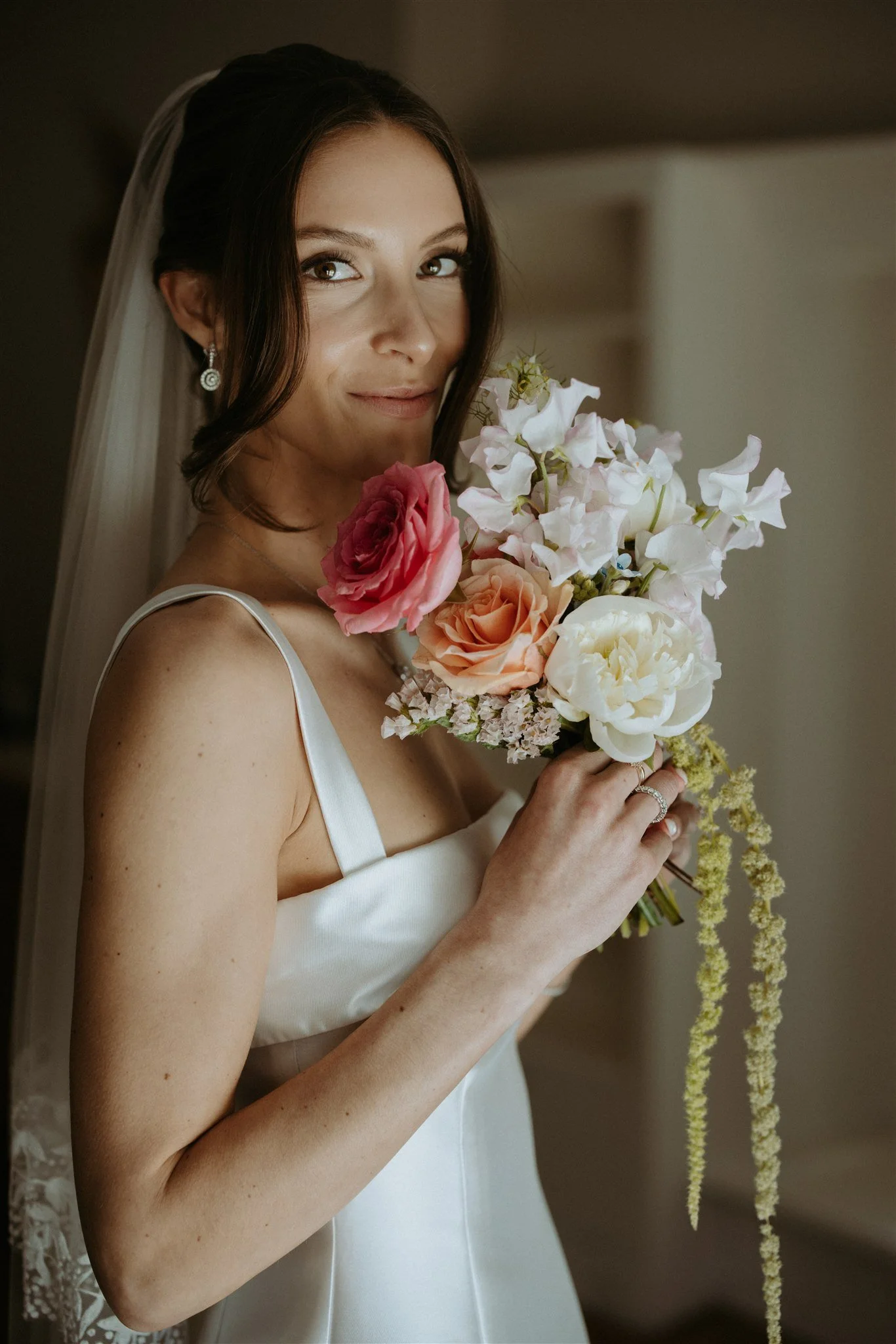 Bride holding an ivory, pink, and peach wedding bouquet by Wild Vogel Works