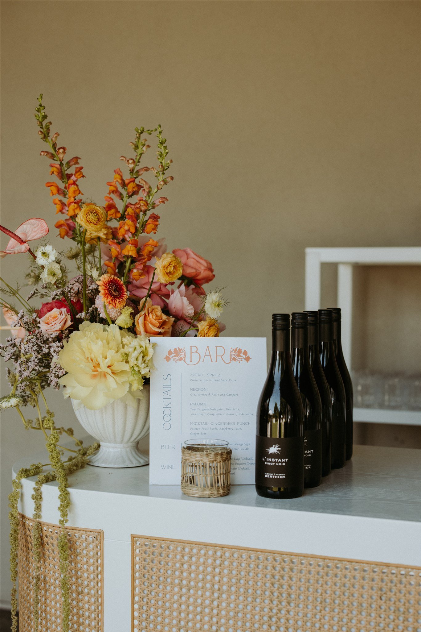Rattan bar with a floral arrangement by Wild Vogel Works