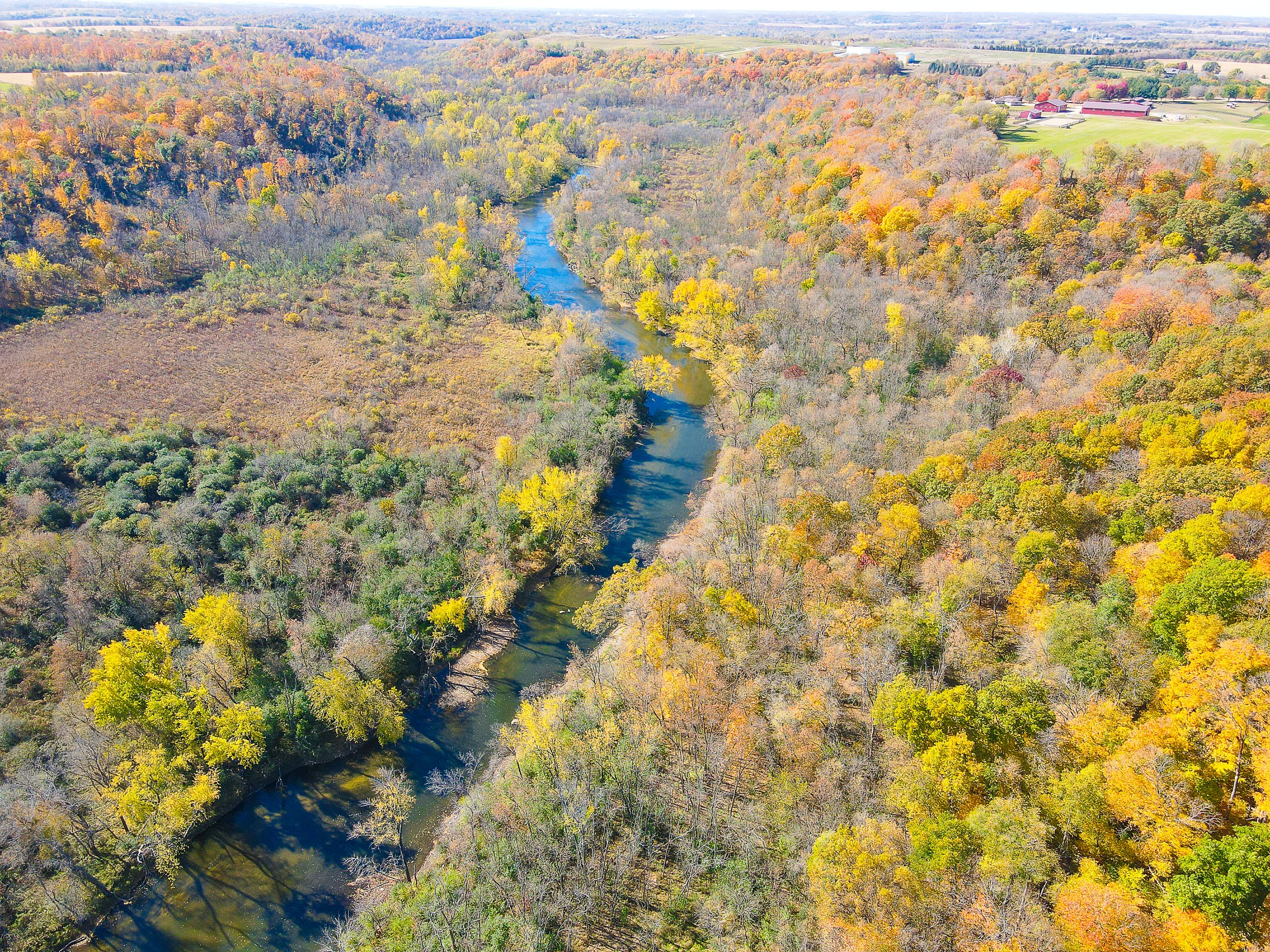 Aerial image of the Cannon River winding through a fall landscape of trees with fall colors.