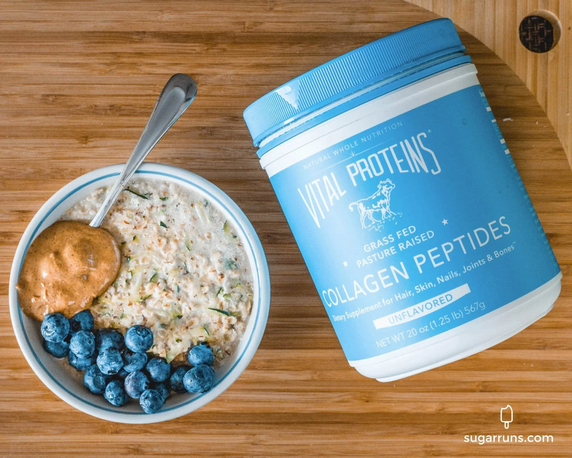 Bowl of oatmeal with blueberries and peanut butter next to a bottle of vital proteins