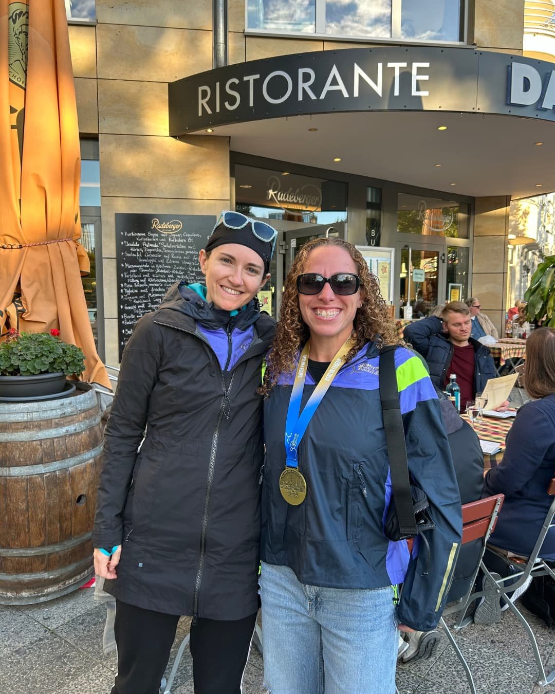 Sandee and Megan standing in front of  a restaurant in Berlin after the marathon.