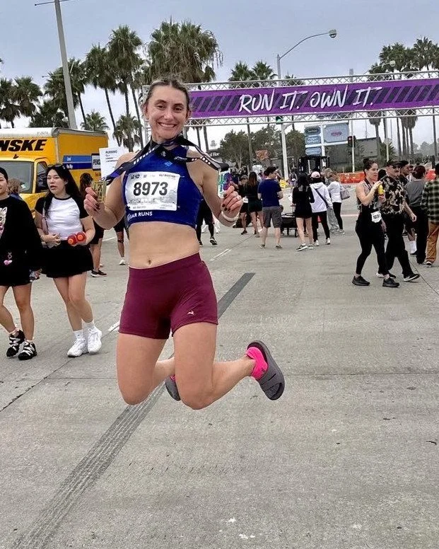 Sam jumping up at the Long Beach Half Marathon finish line in celebration