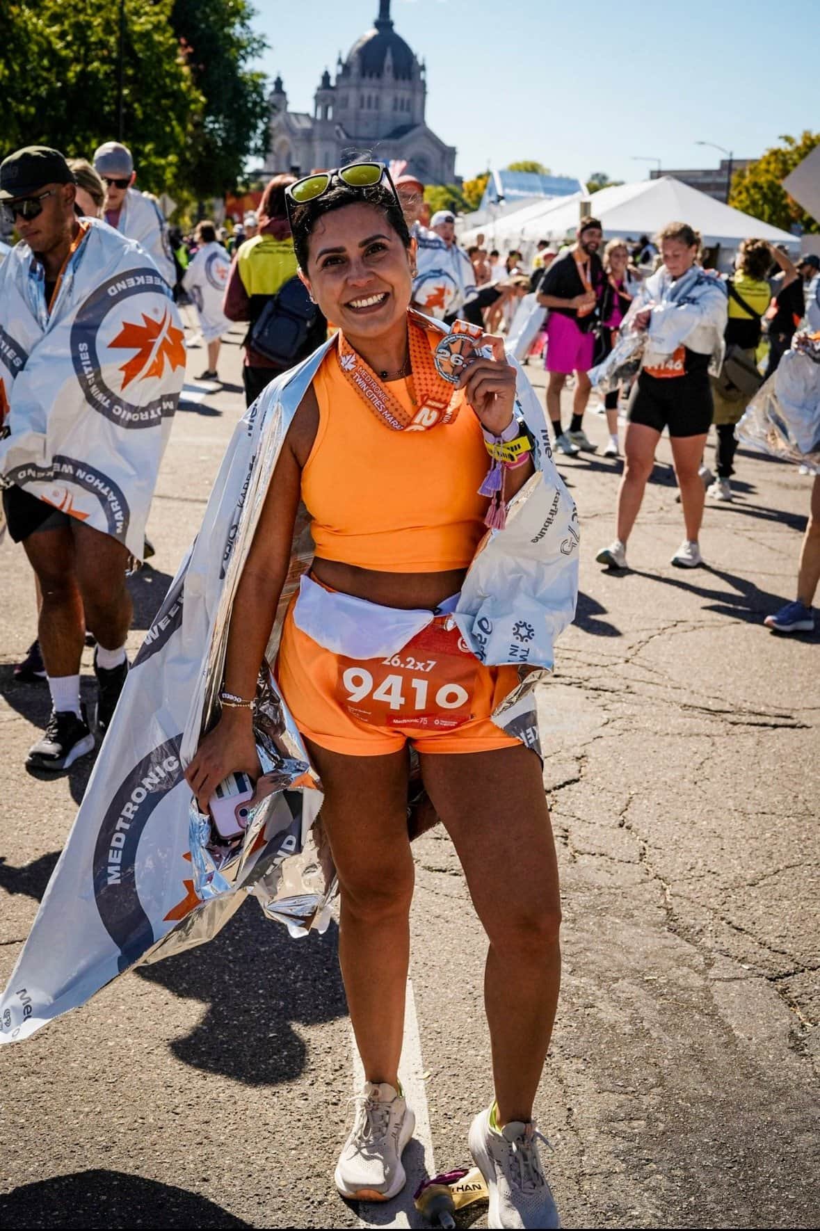 Woman holding a medal at the end of Twin Cities Marathon