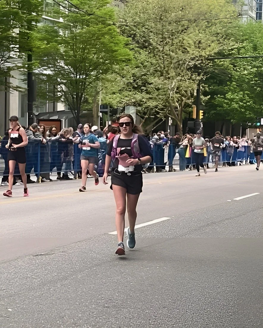 Woman running a marathon with a hydration vest.