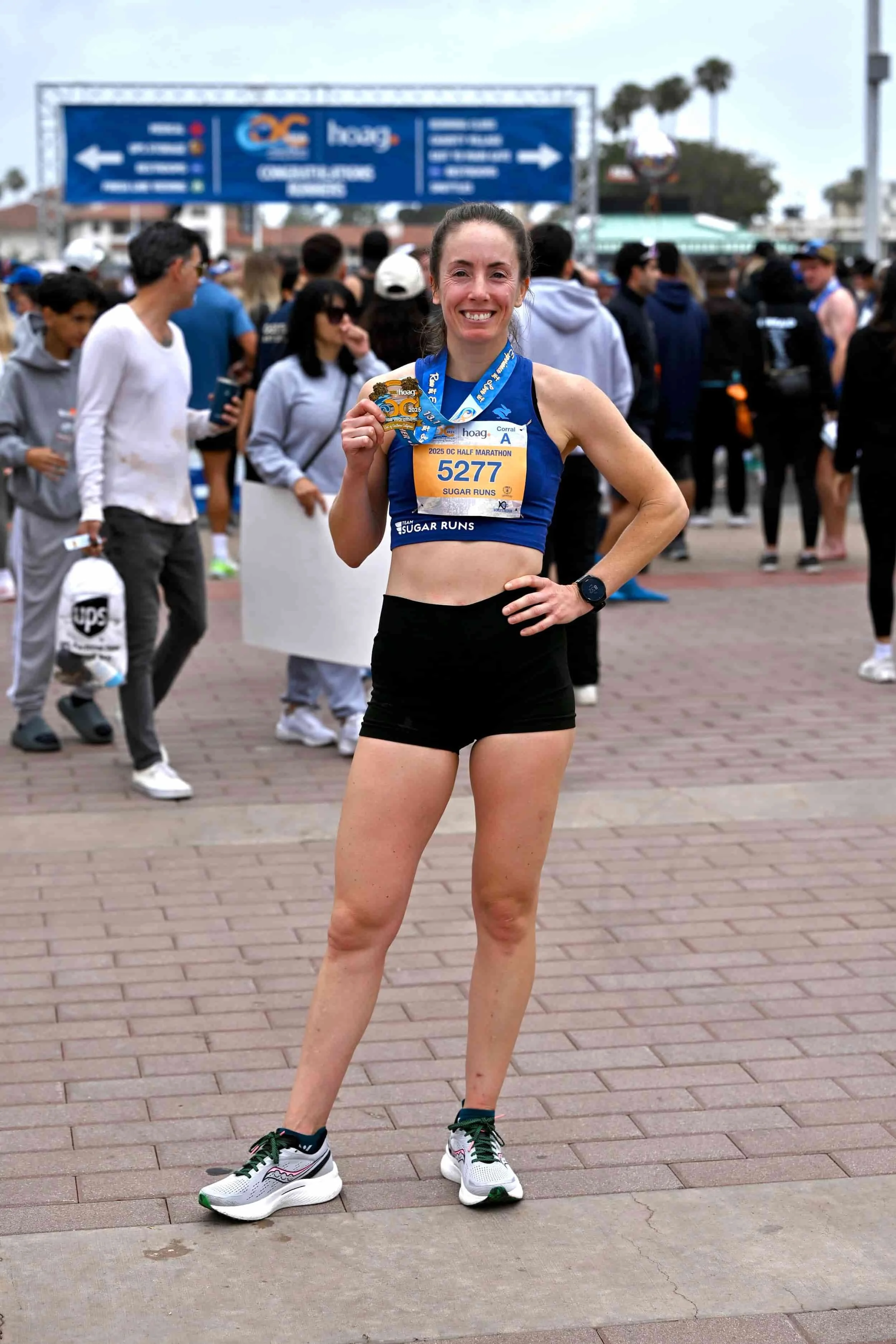 Woman holding a medal after the OC Half Marathon
