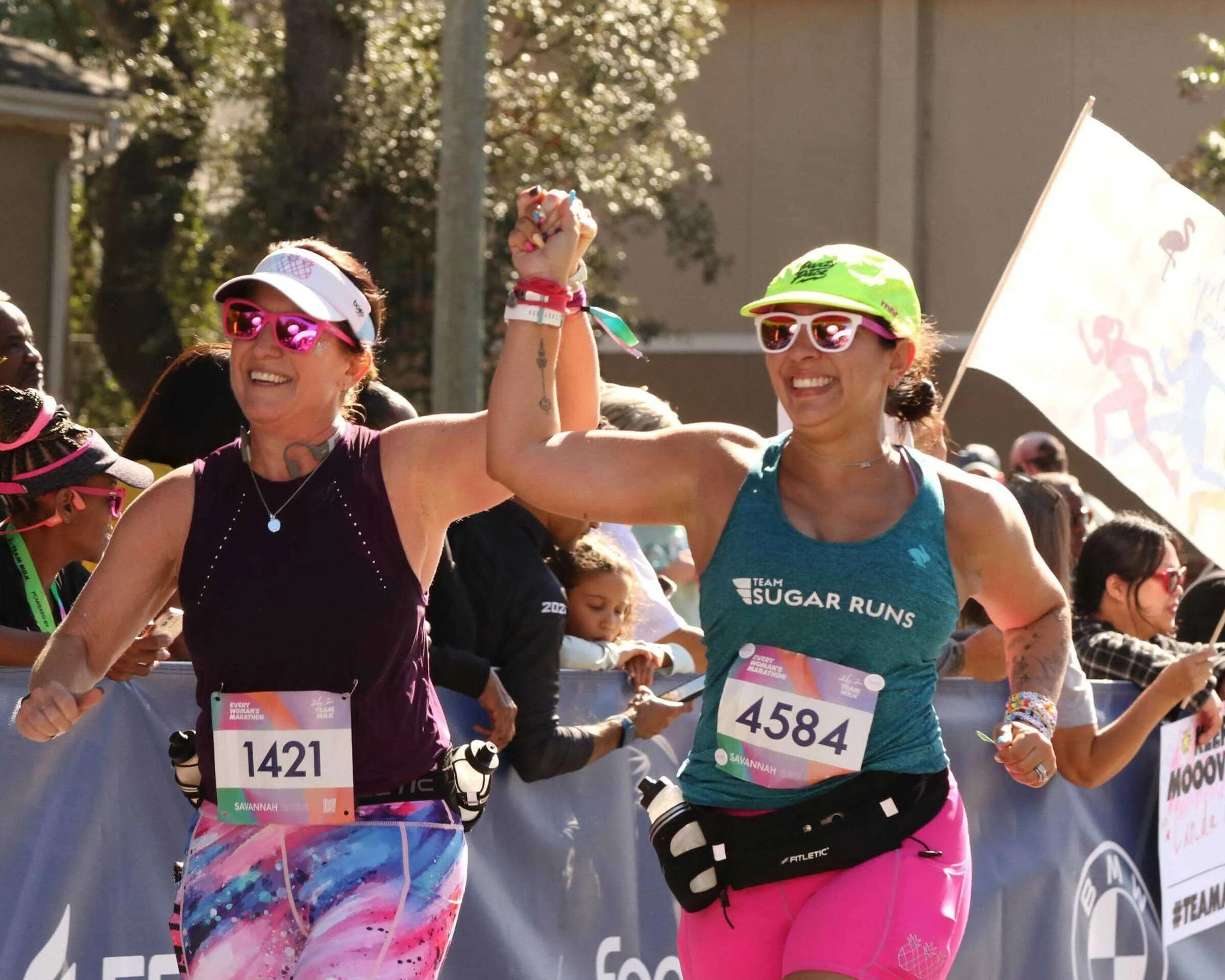 Two Women Holding Hands Headed Towards Every Woman's Marathon Finish Line