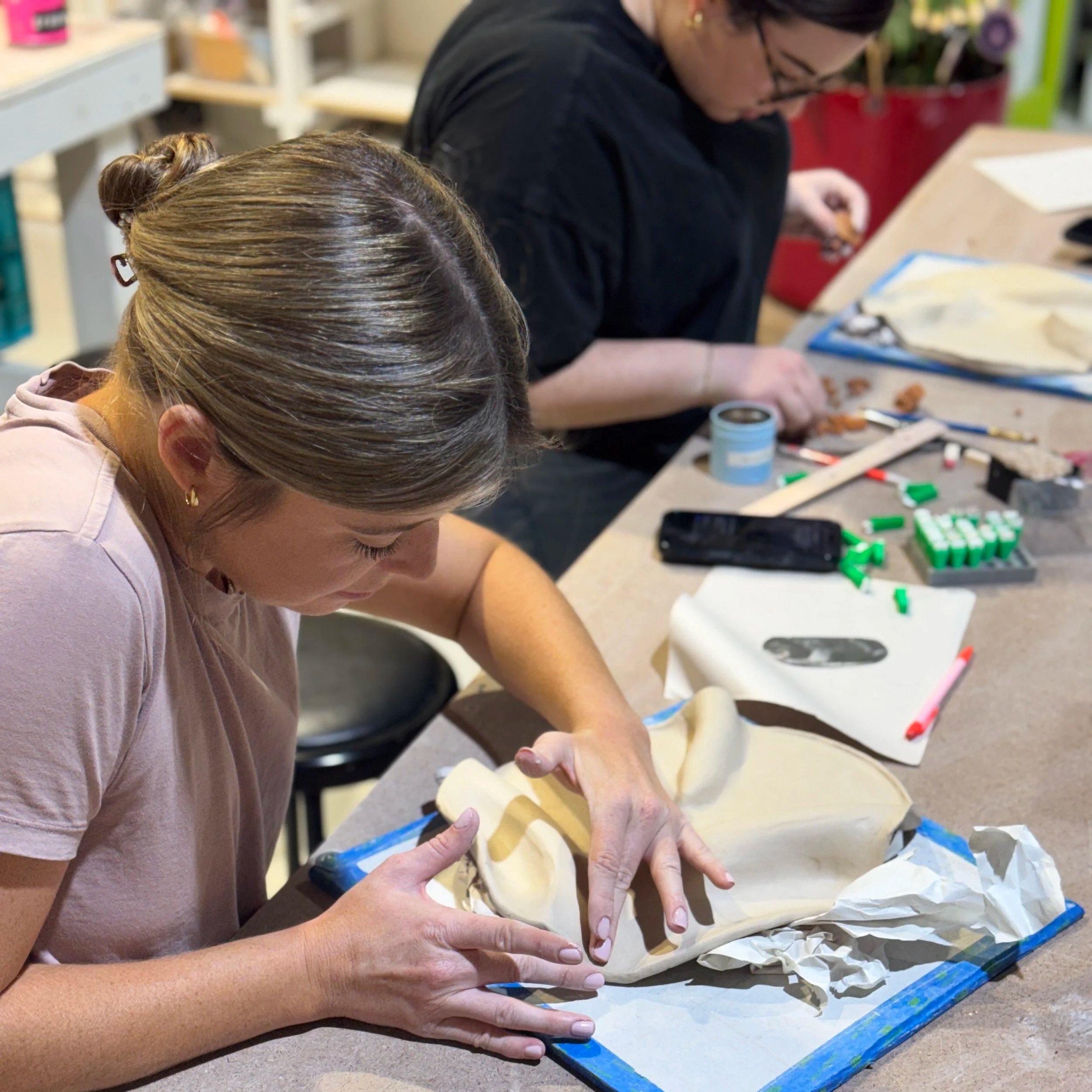 Pink flyer promoting a handmade charcuterie board workshop with an image of a cheese and meat platter including cheeses, cured meats, nuts, grapes, and dried fruits.