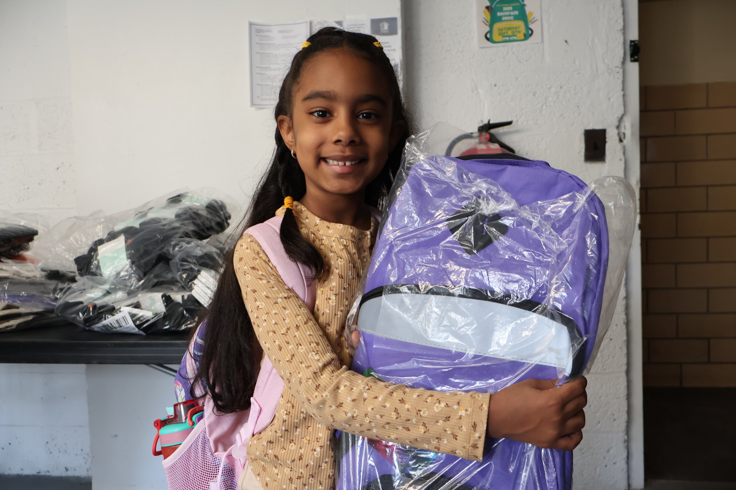 Photo showing the distribution of backpack kits to children.