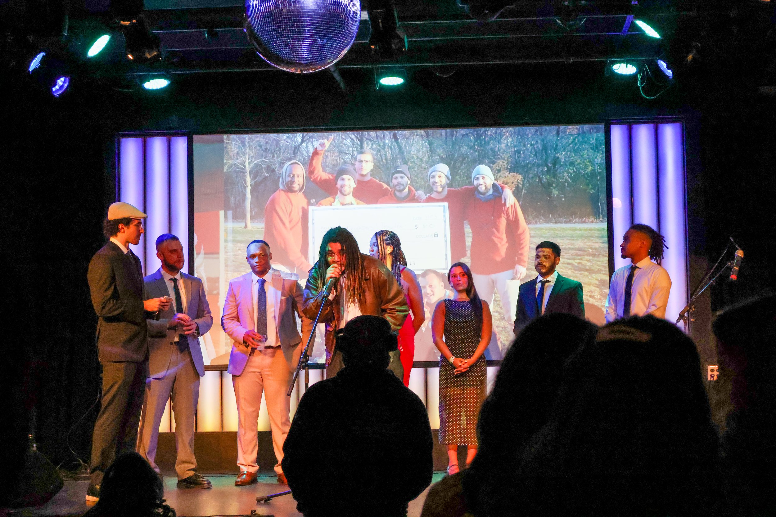 The live band, Zamba 2 Samba, performing on stage with lights and energy.