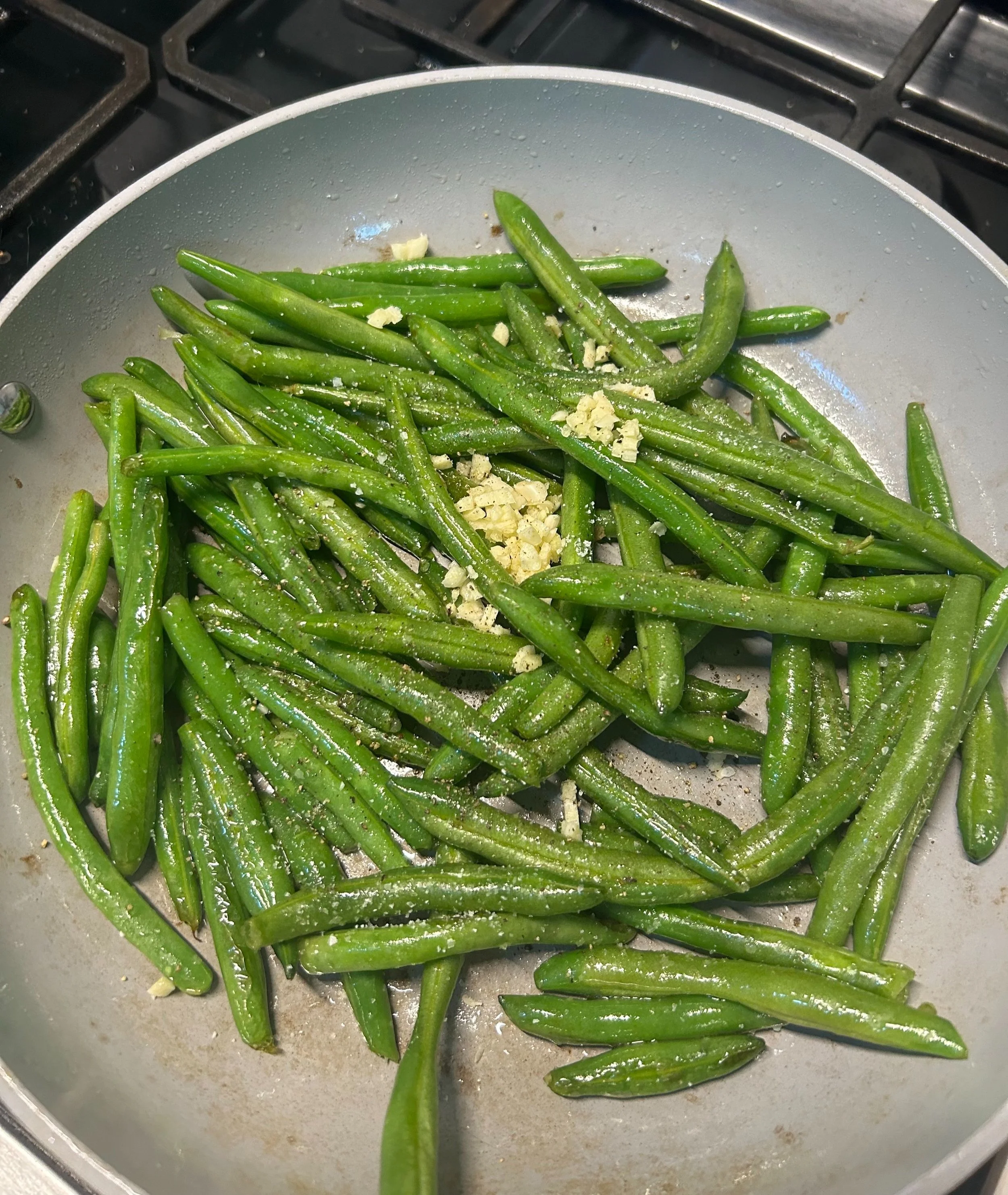 Green beans sautéing in a hot pan, almost ready to be coated in balsamic glaze