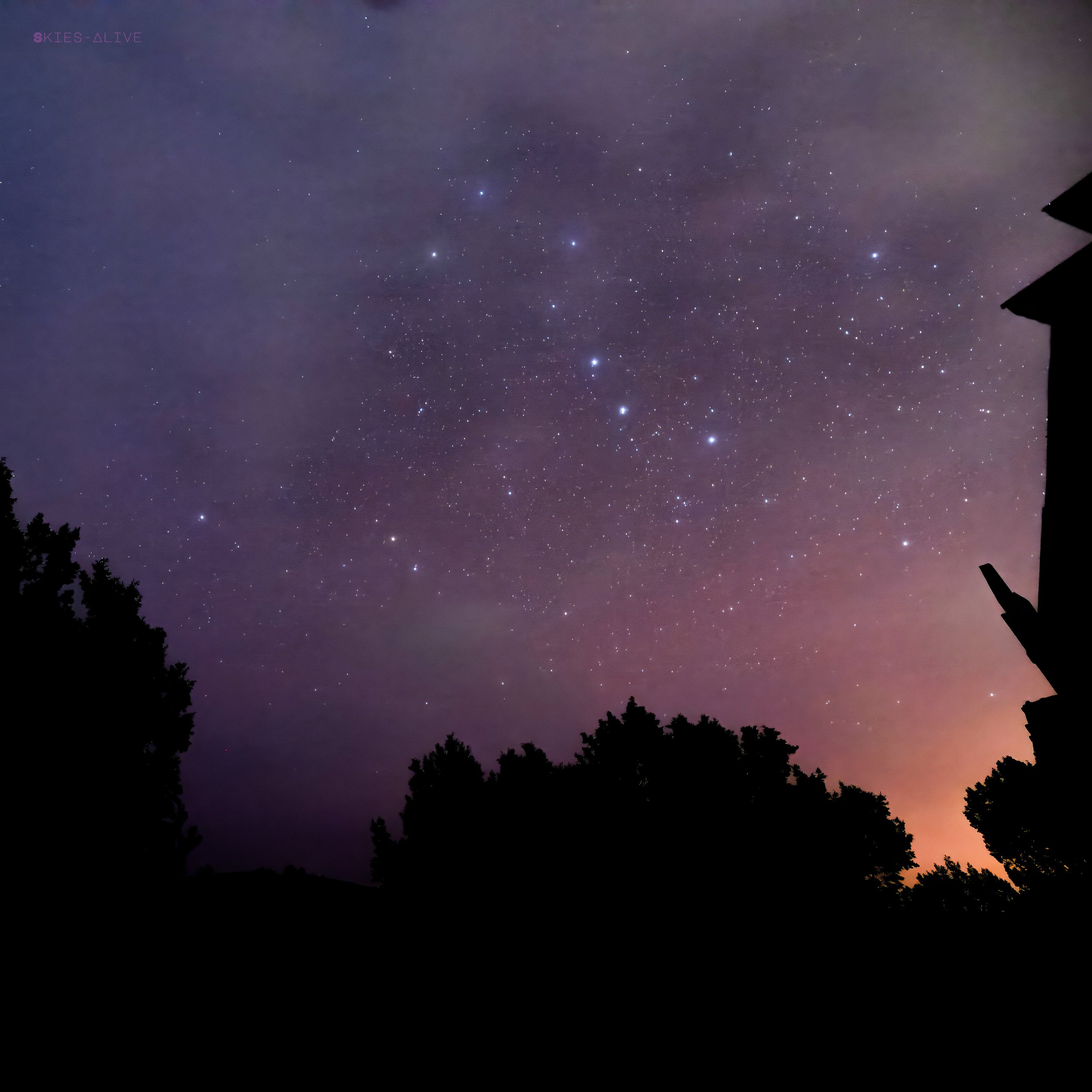 Big dipper bathed in the pink and orange glows of natural and artificial light.