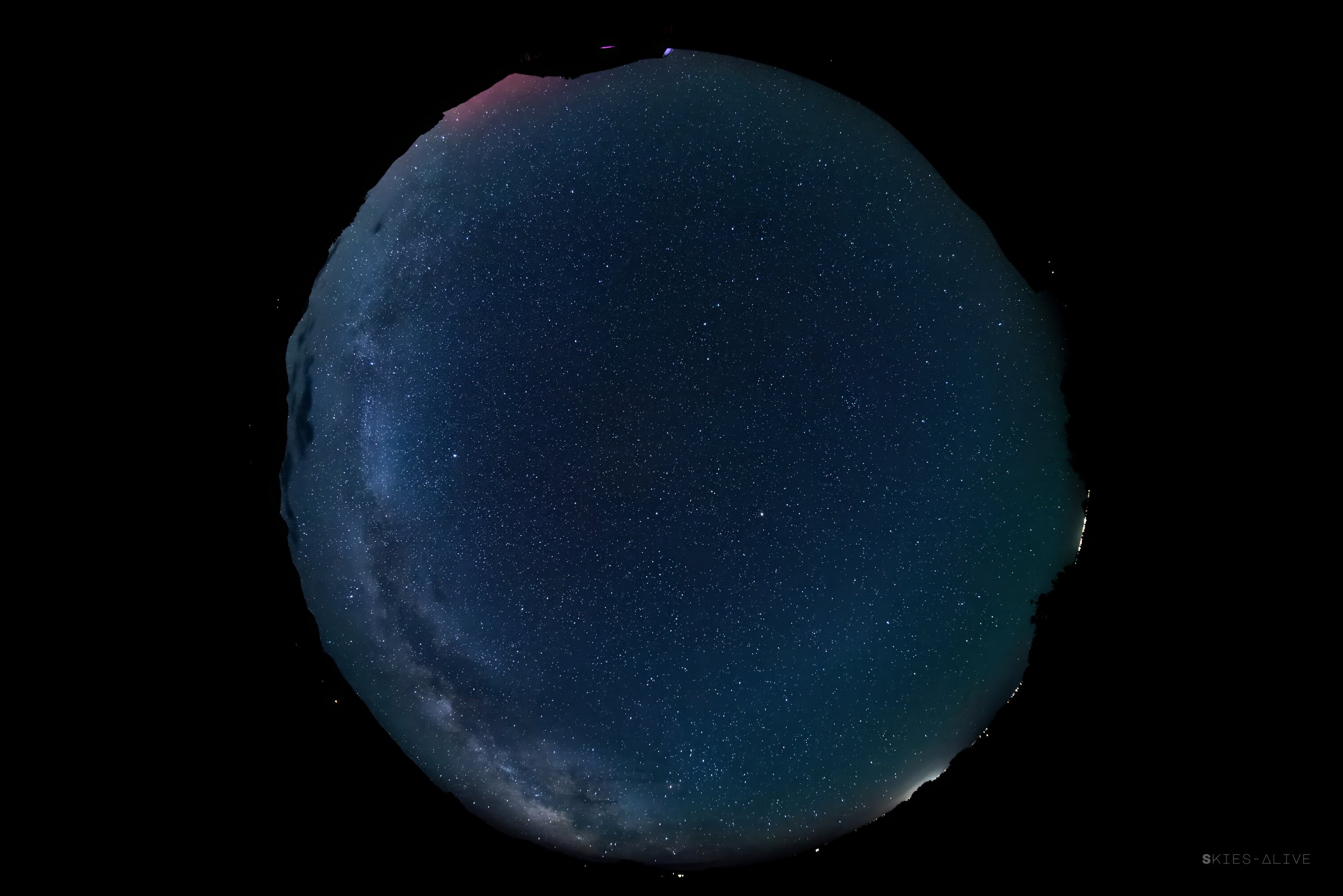 Fish eye view - pink aurora to the north, artificial lights from Alamosa to the south.
