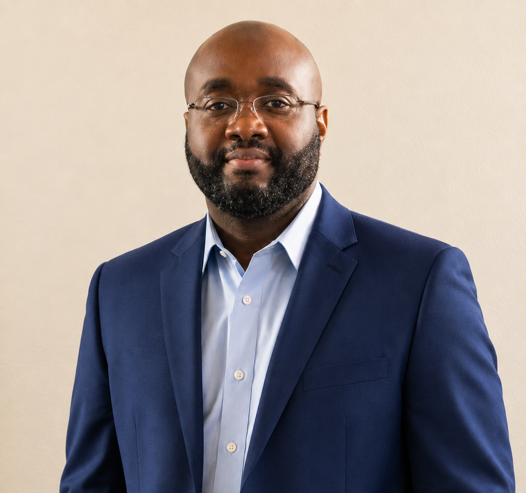 Man smiling in a suit with glasses