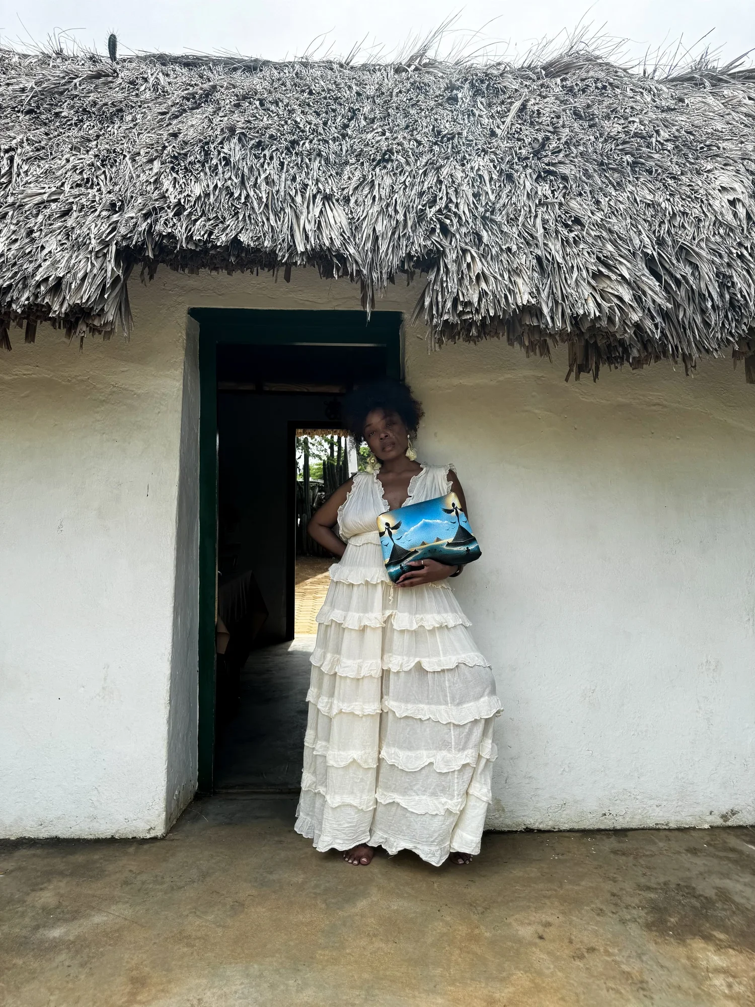 Model holding a handmade leather clutch purse with a unique print depicting the Ancient Sibylline Oracles.