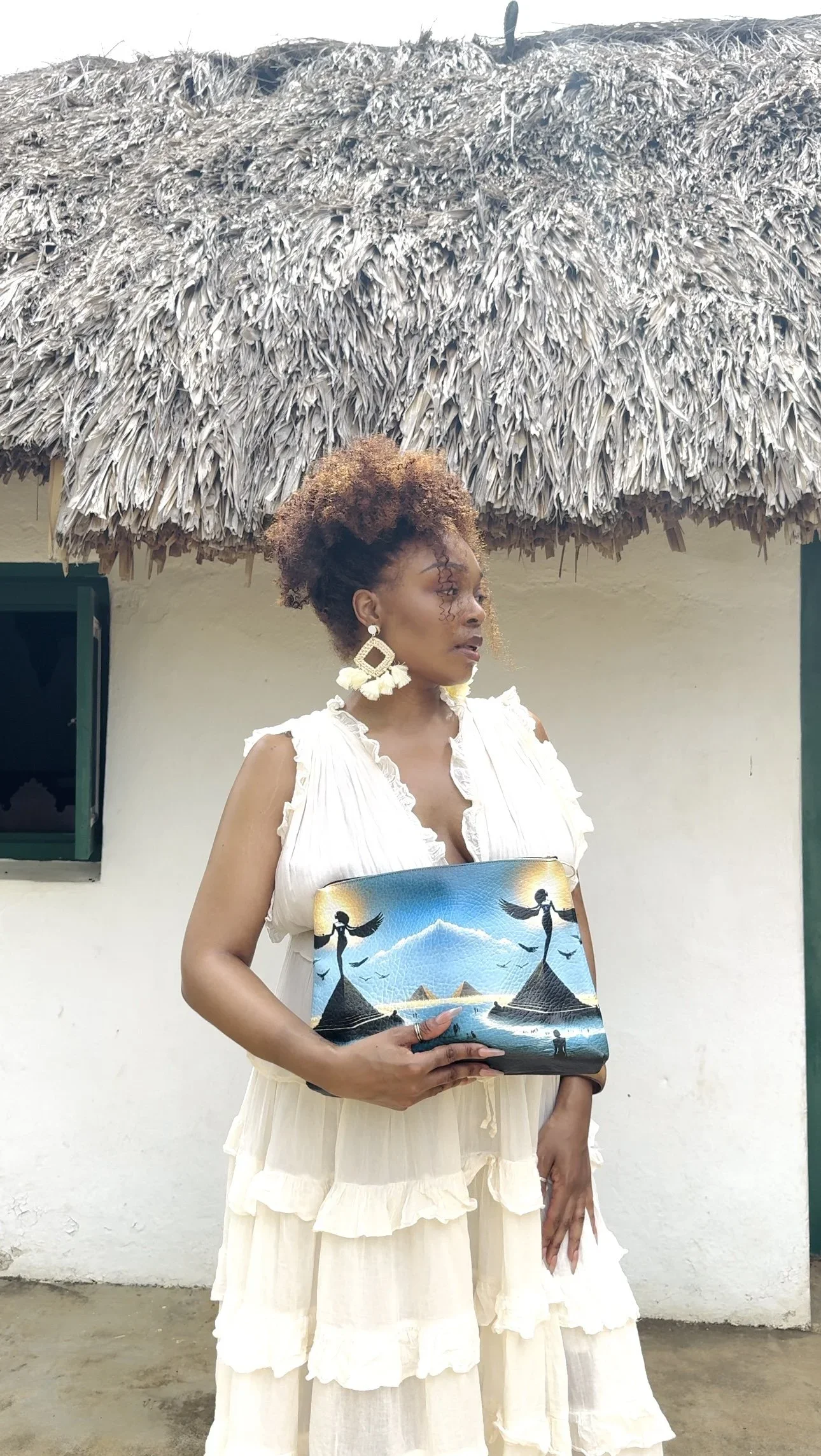 Model holding a handmade leather clutch purse with a unique print depicting the Ancient Sibylline Oracles.