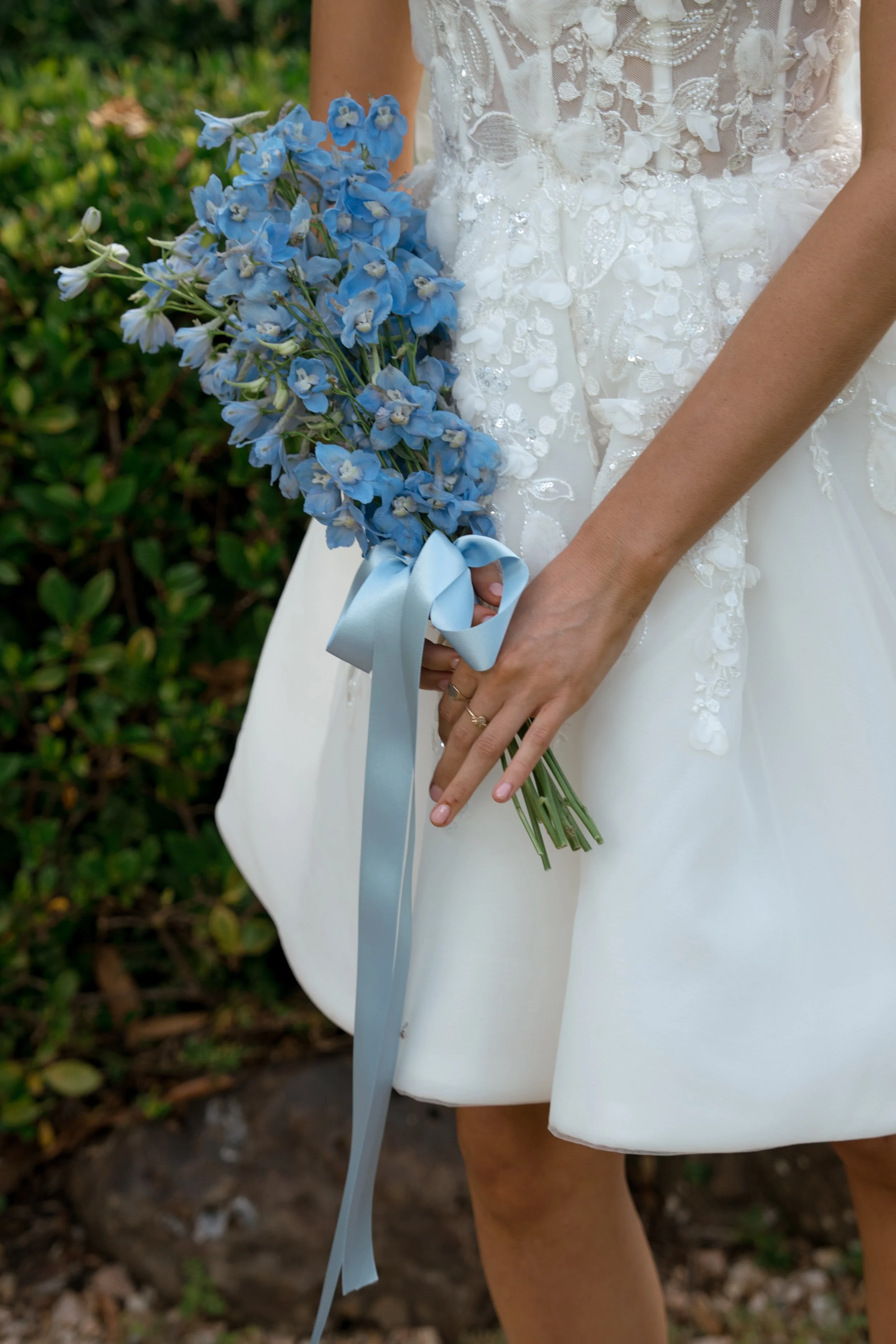 Bride holding blue flower bouquet
