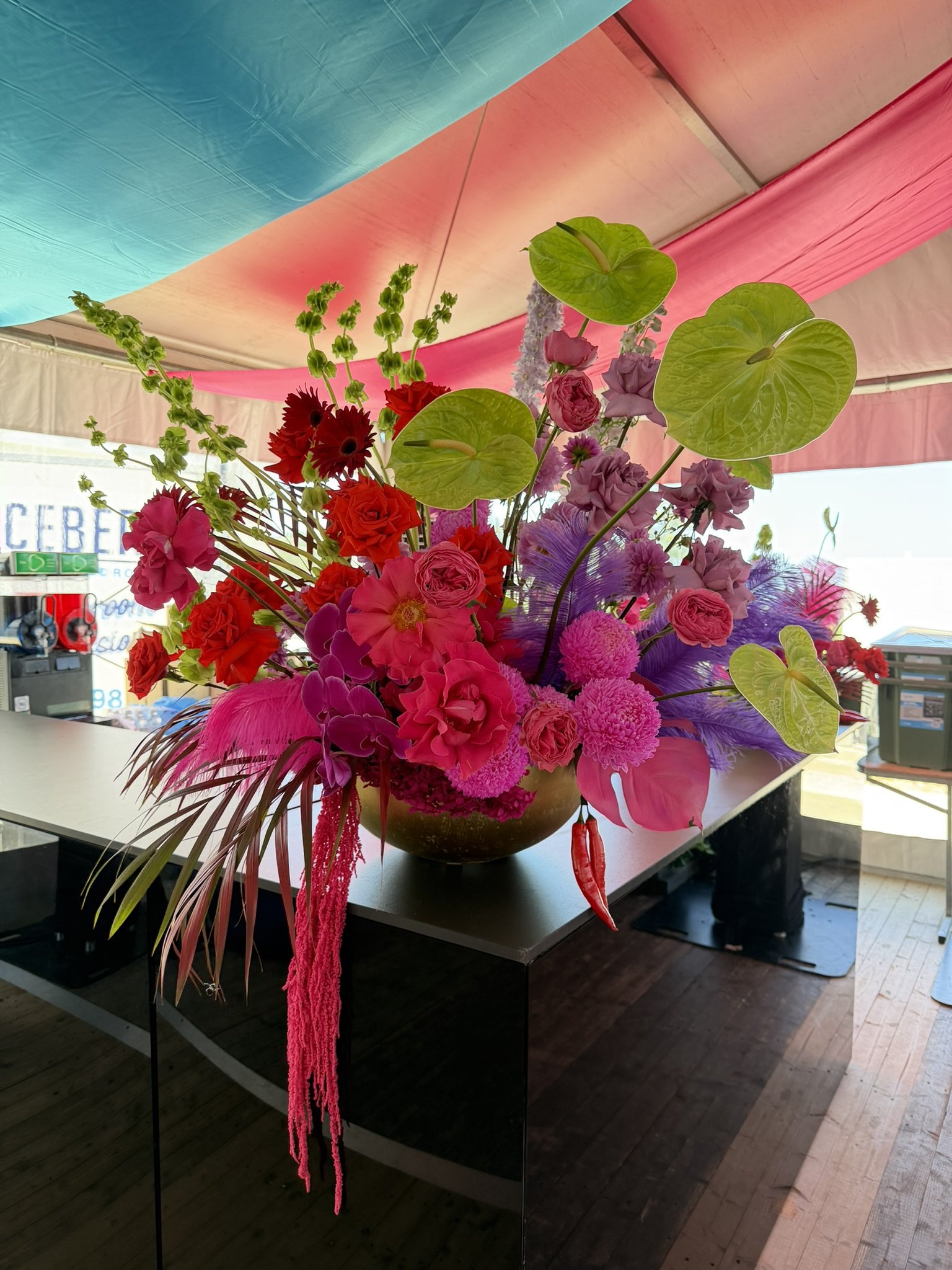 Big vase of pink, green and purple flowers at a Corporate event