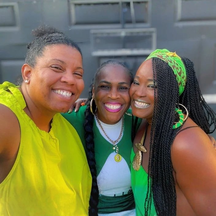 Cheryl, Natasha & Makresha dressed in various shades of green smiling big for the camera