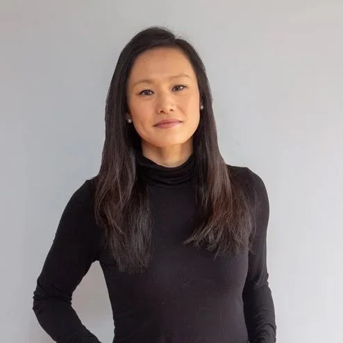 Woman in black turtleneck and jeans against a white background.