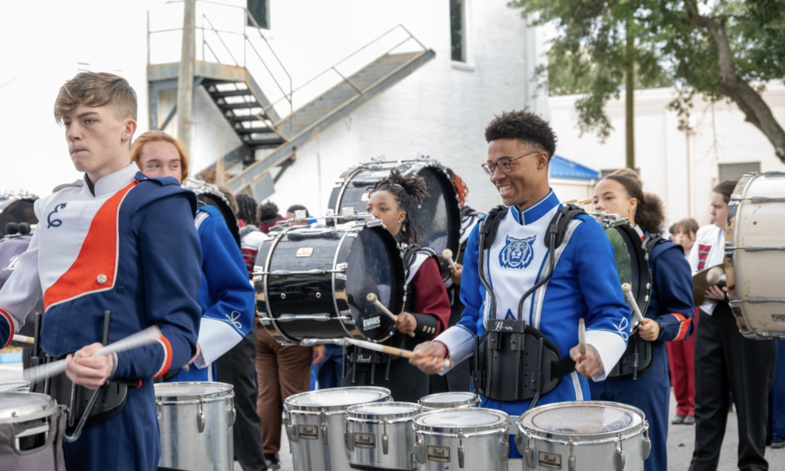 high school band drum section walking done the street during parade