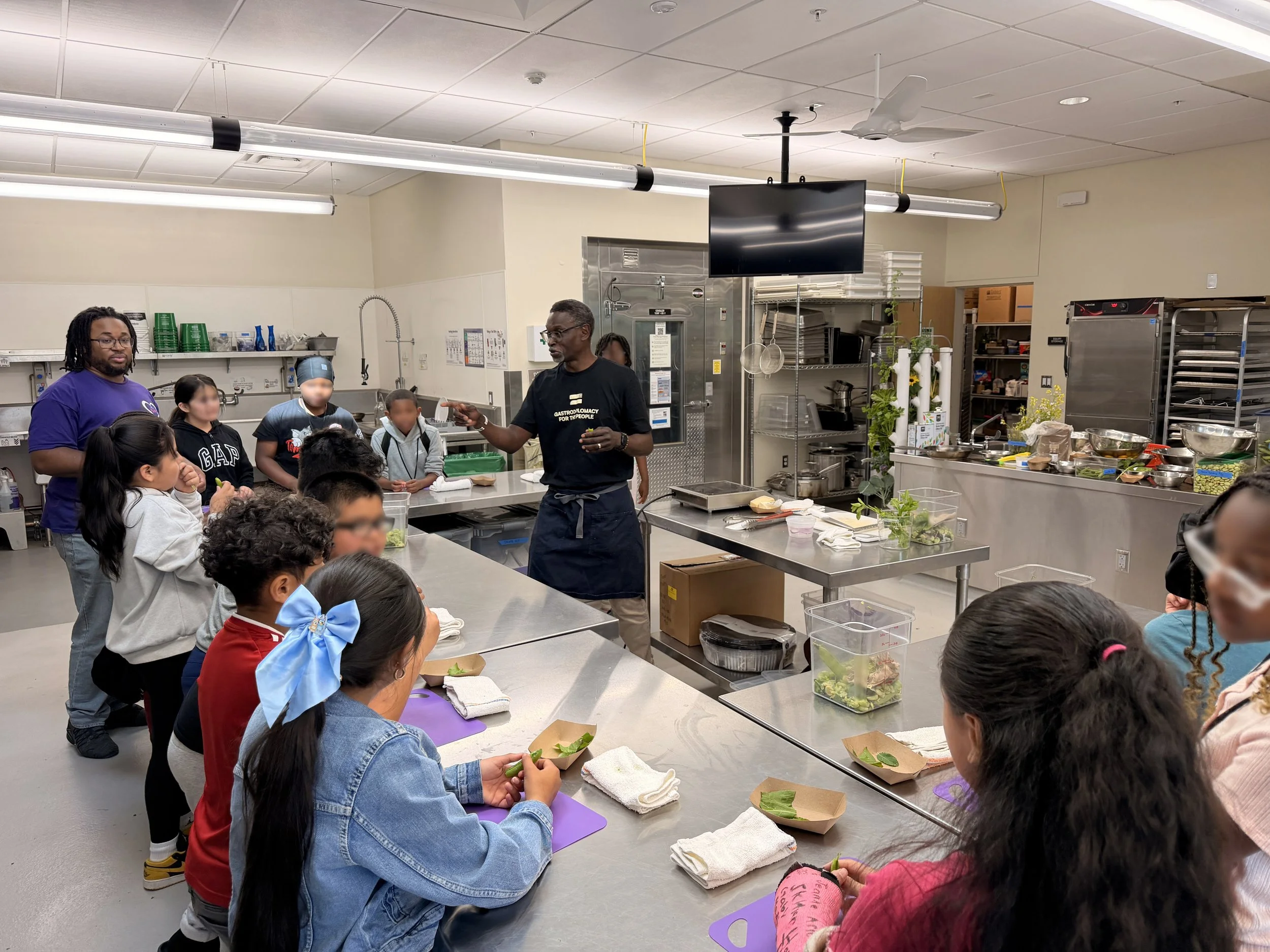 Image showing Chef Pierre teaching a group of young students a cooking class in a culinary classroom