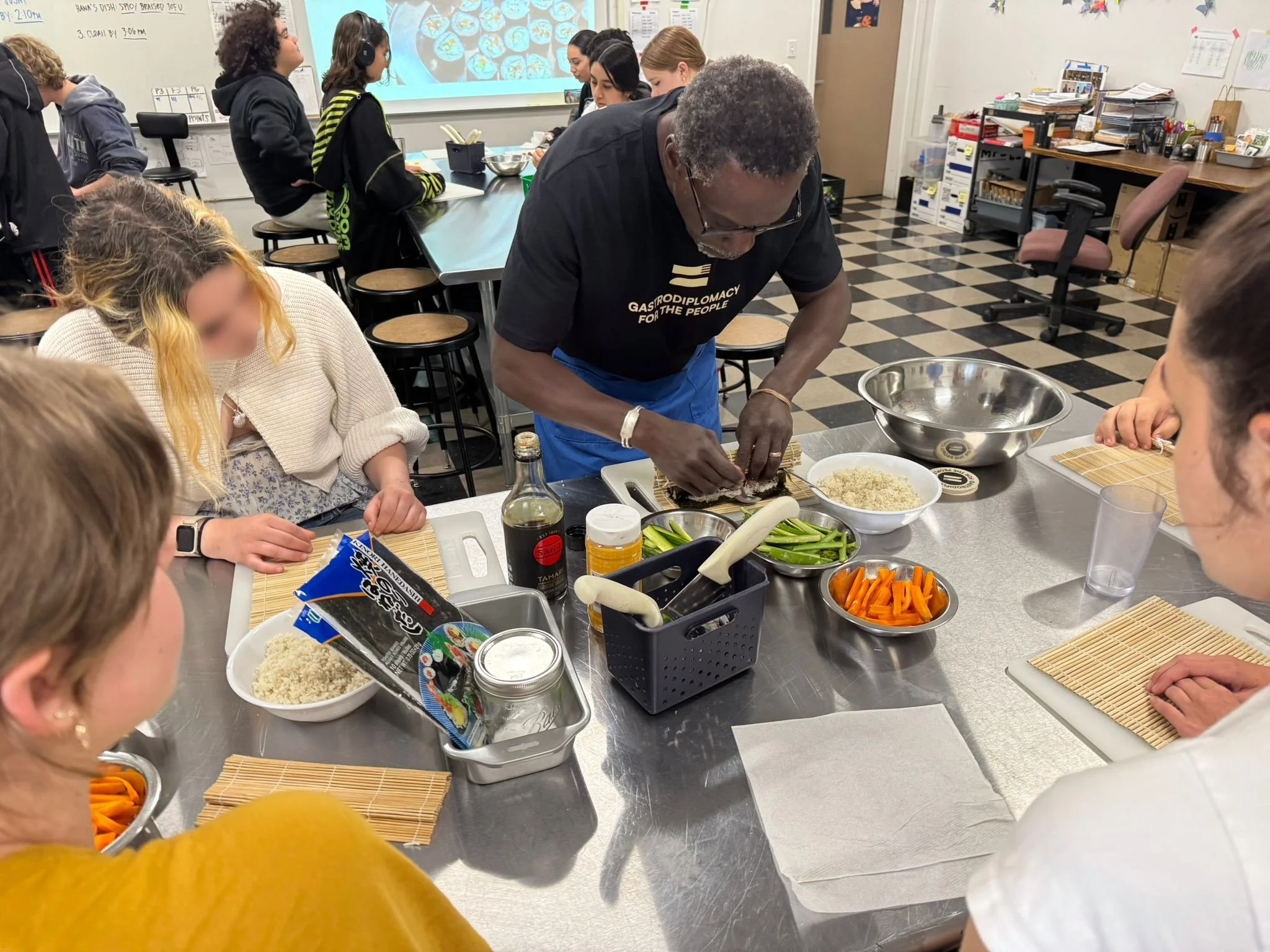 Chef Pierre shows students in a culinary demo how to make fonio sushi rolls.