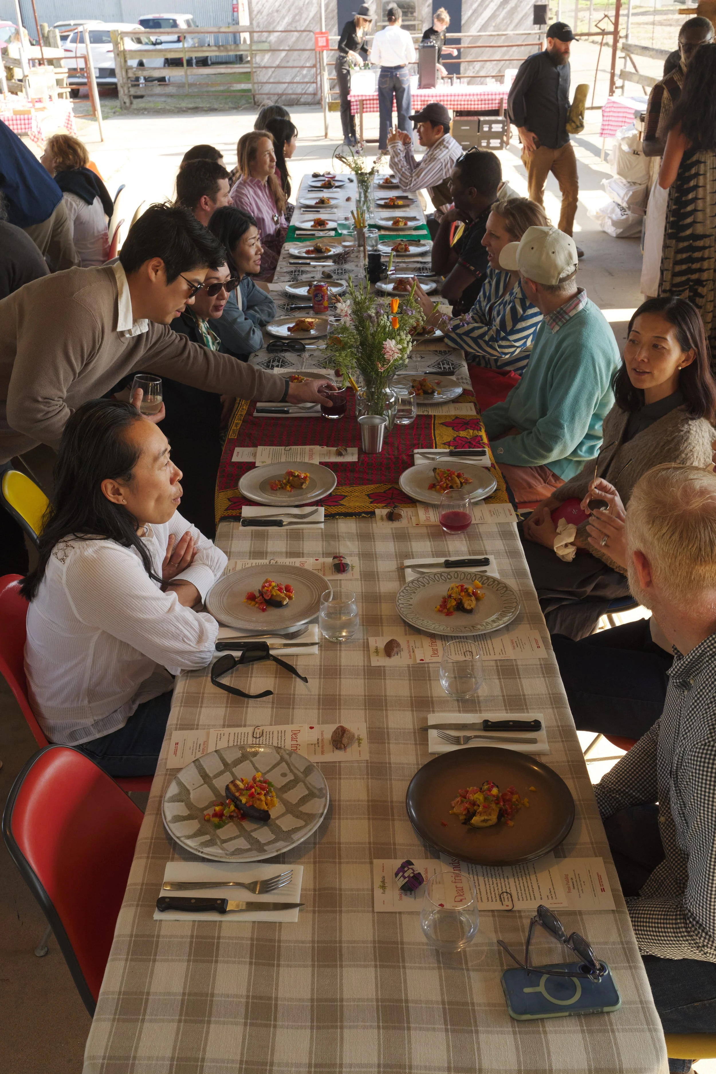 Guests seated at a long table at the Eames Ranch during a Gastrodiplomacy dinner event