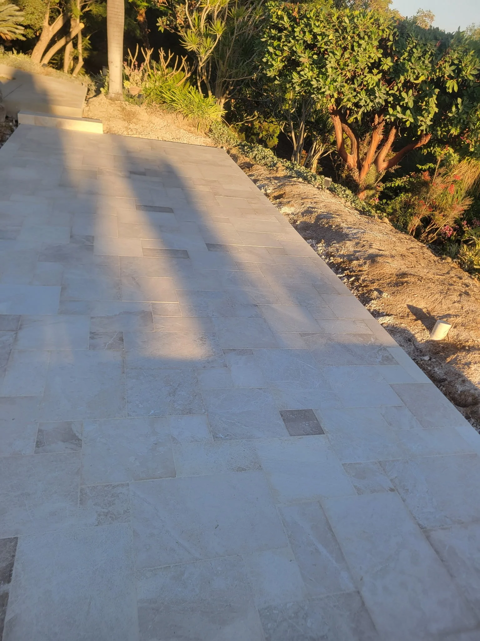 Custom backyard concrete installation connecting home patio door to outdoor living space, designed for durability, drainage, and modern hardscape aesthetics.