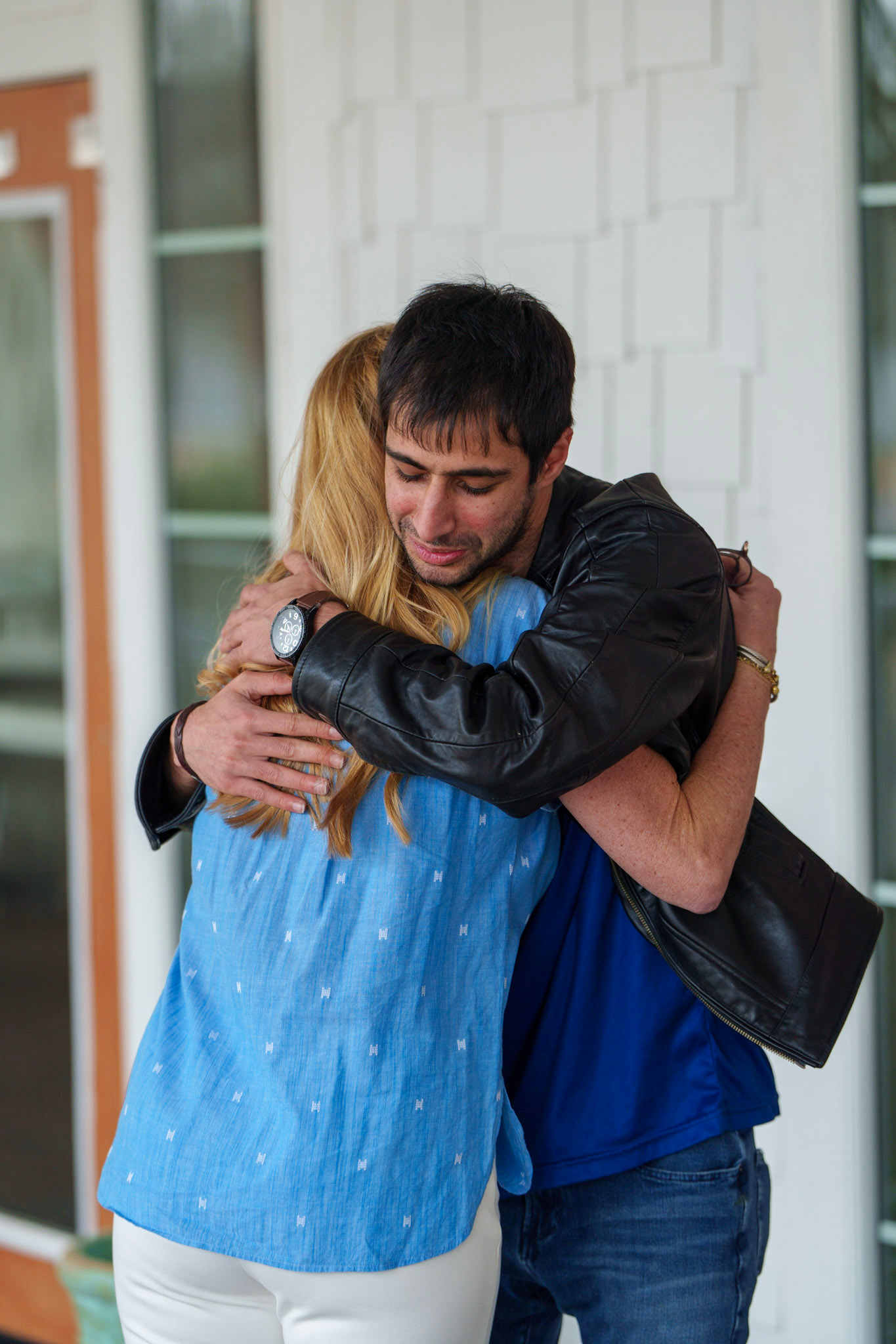 Two people hugging emotionally outside a building.