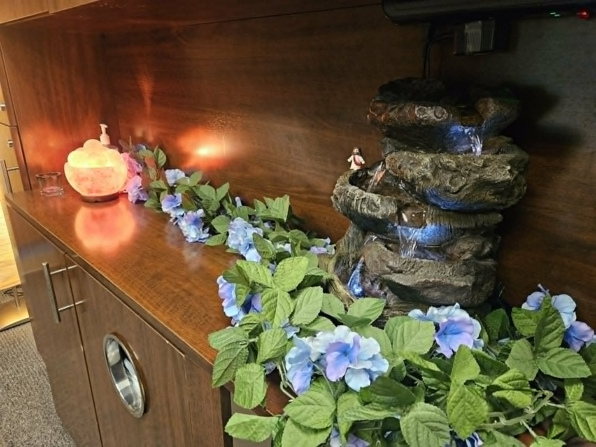 Serene fountain and warming salt lamp assist in relation at Soothe Total Wellness.