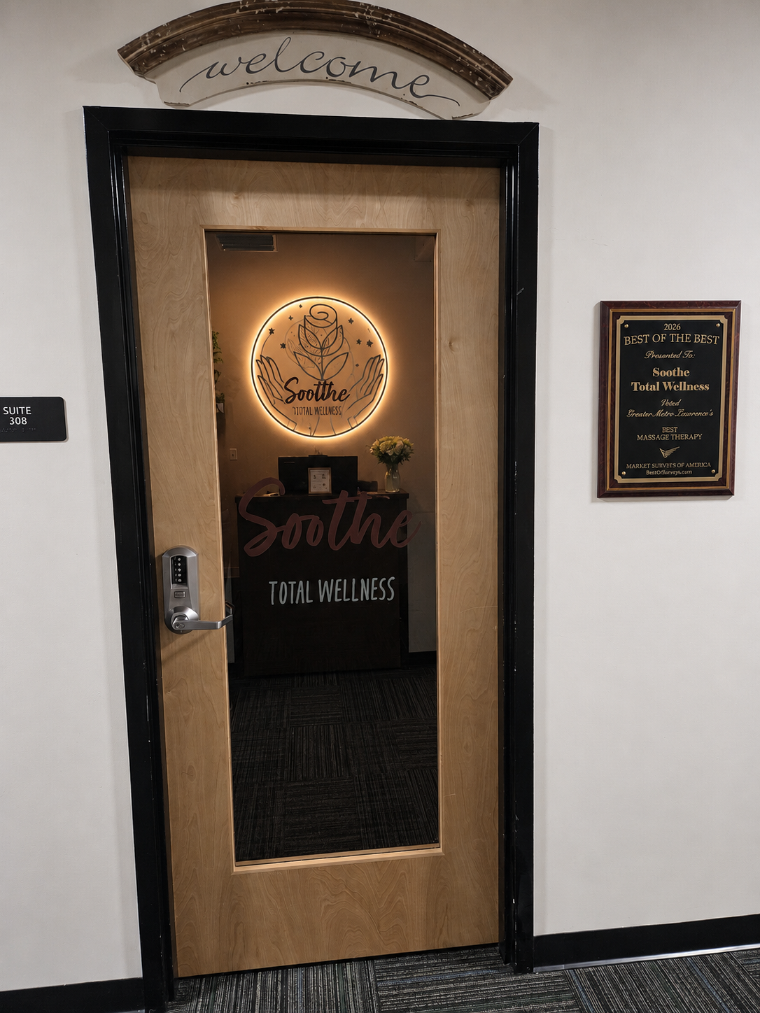 Front entrance to Soothe Total Wellness with a plaque indicating its in suite 308 and an award for "Best Massage Therapy".