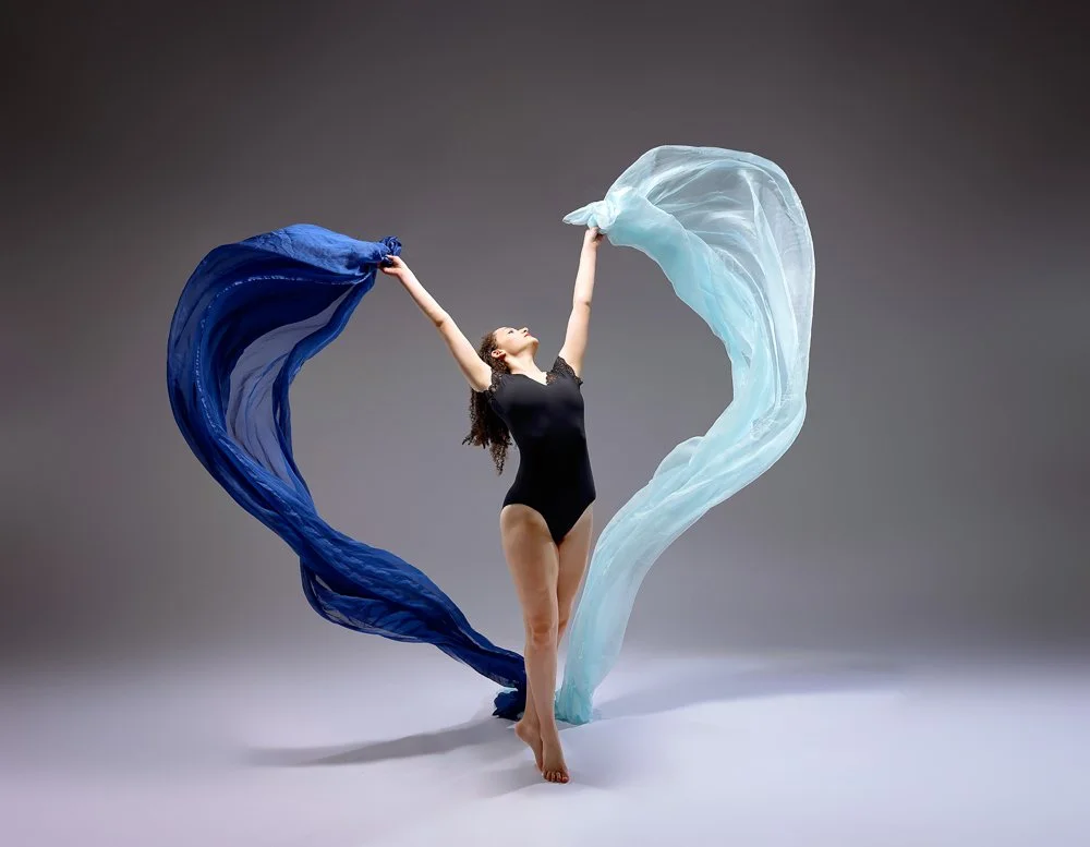   Dancer moving with flowing fabric during a studio dance photoshoot  
