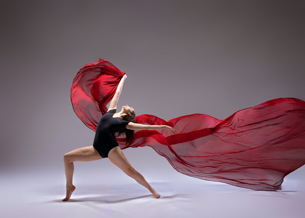   Flowing fabric dance portrait with soft, dramatic motion    