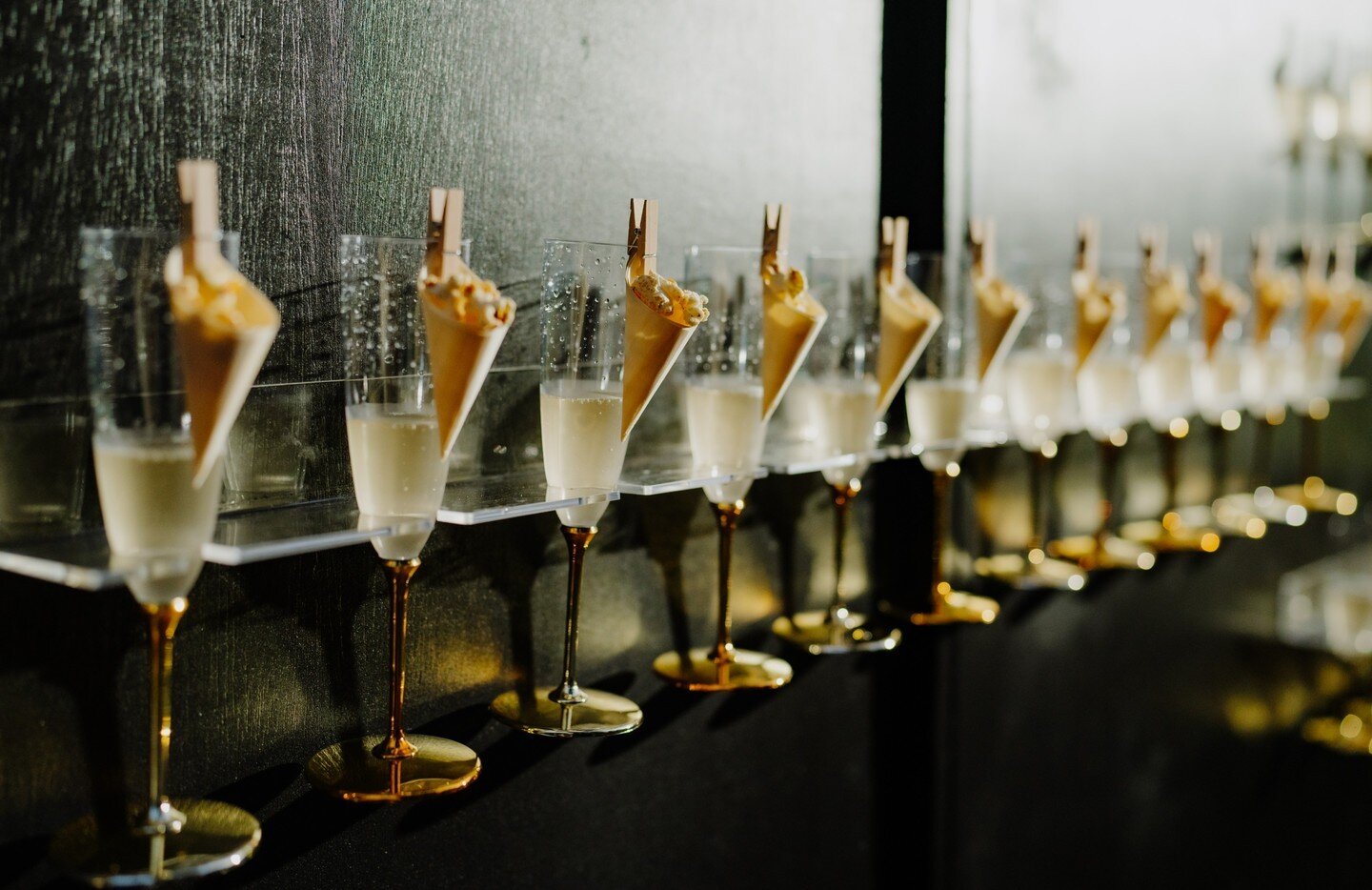 Welcome your guest with simple touches to your event that Speak Sophisticated Hospitality but are Stylish.  Eco-friendly disposable flutes with gold bottoms filled with champagne are stunning, especially paired with a tiny cone filled with popcorn. B