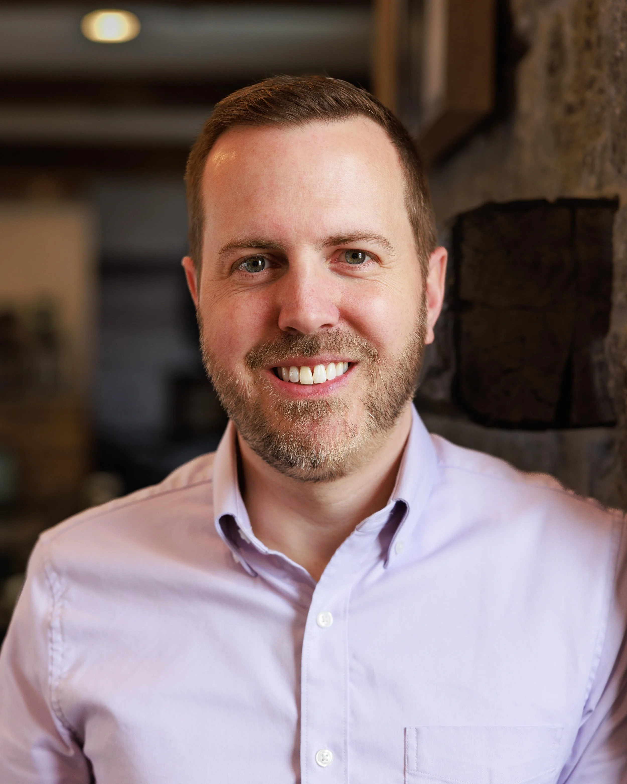 A headshot of Shaun Boyle, Founder of TaberNext, smiling at the camera and wearing a lavender dress shirt.