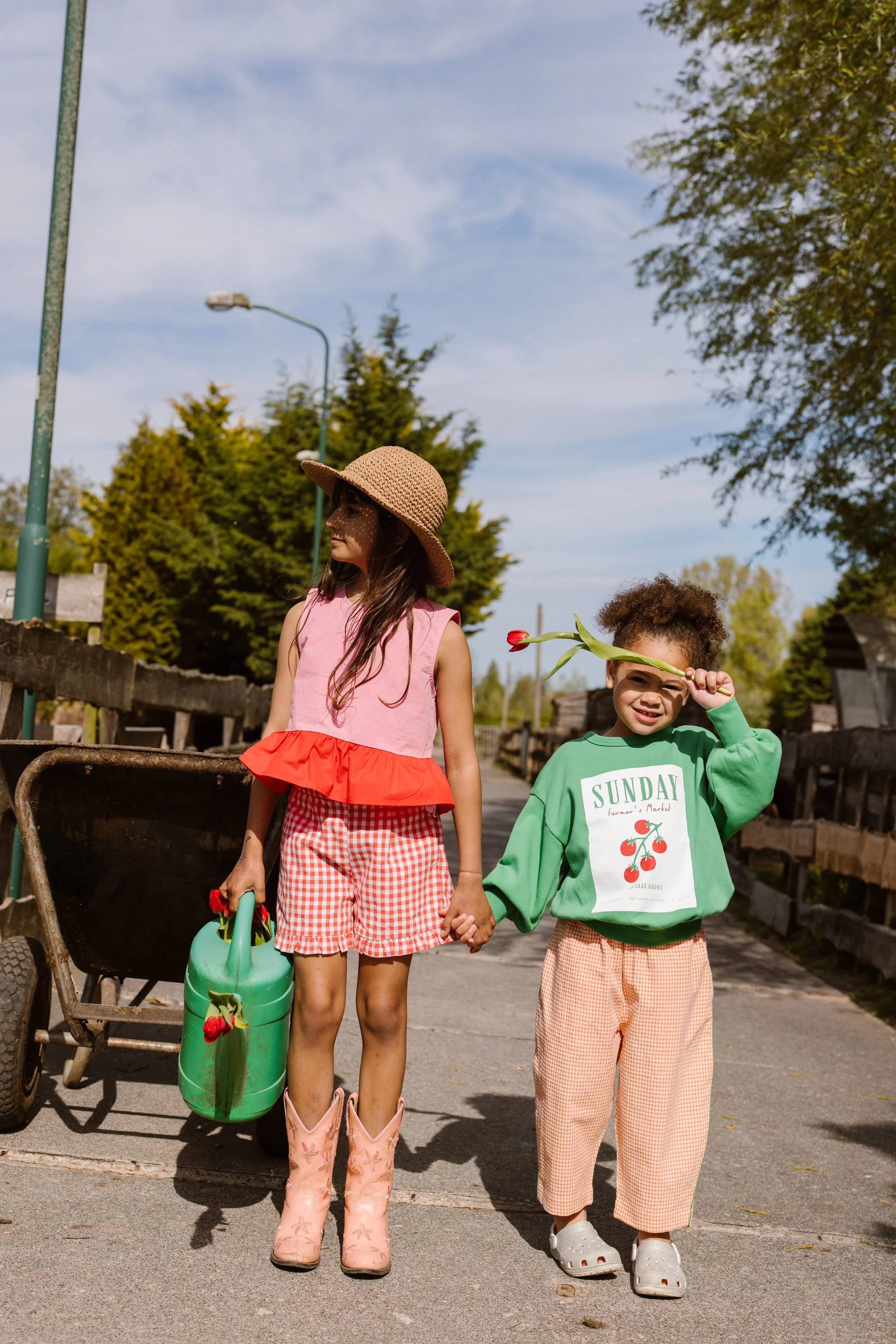 Two young girls holding hands and walking outdoors at the farm. fashion shoot, lifestyle shoot, brandshoot, lieneloe fashion haarlem