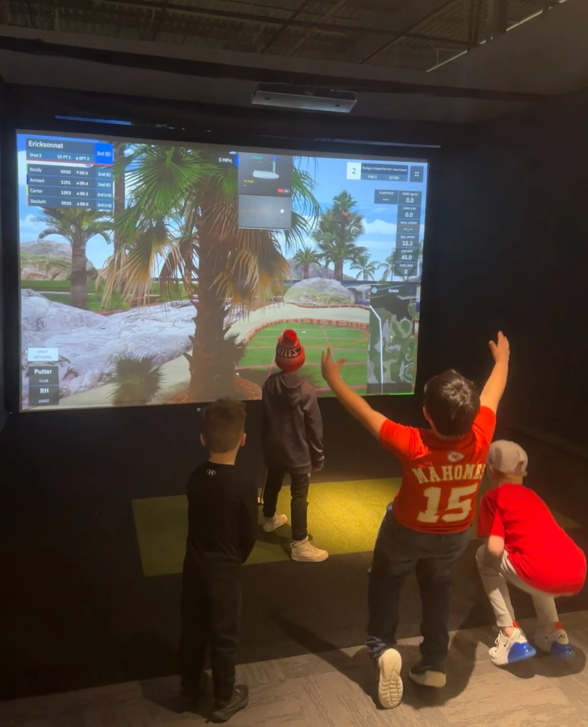 Junior golfers playing on a simulator at WIG