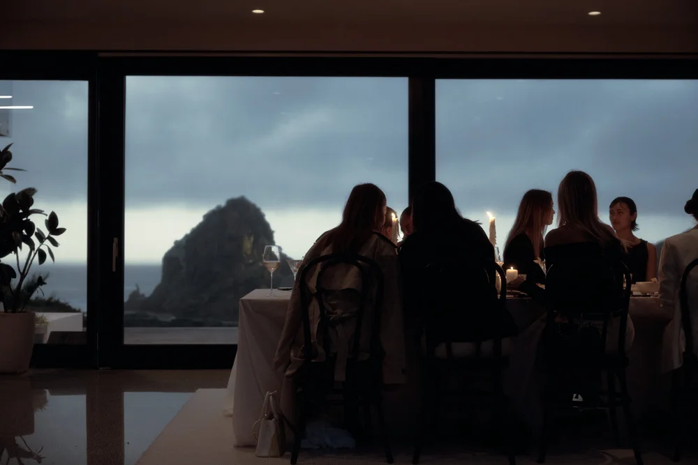 Guests at dinner silhouetted against Lion Rock