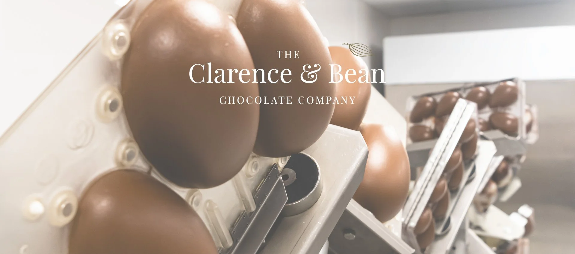 Close-up of chocolate easter eggs in a manufacturing facility with the text 'Delivering Quality Handcrafted Chocolate' overlaid.