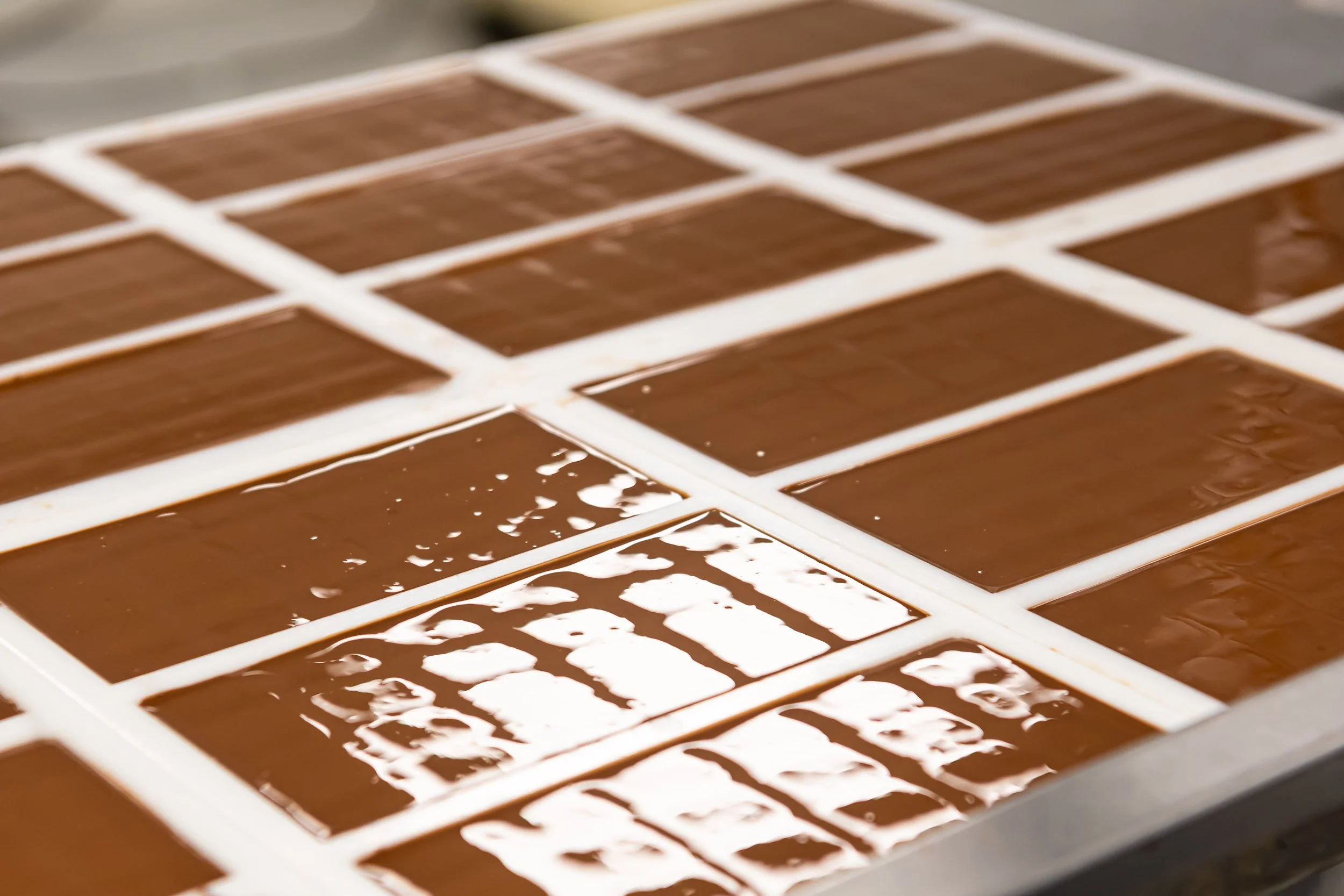 Close-up view of a chocolate mould filled with melted chocolate