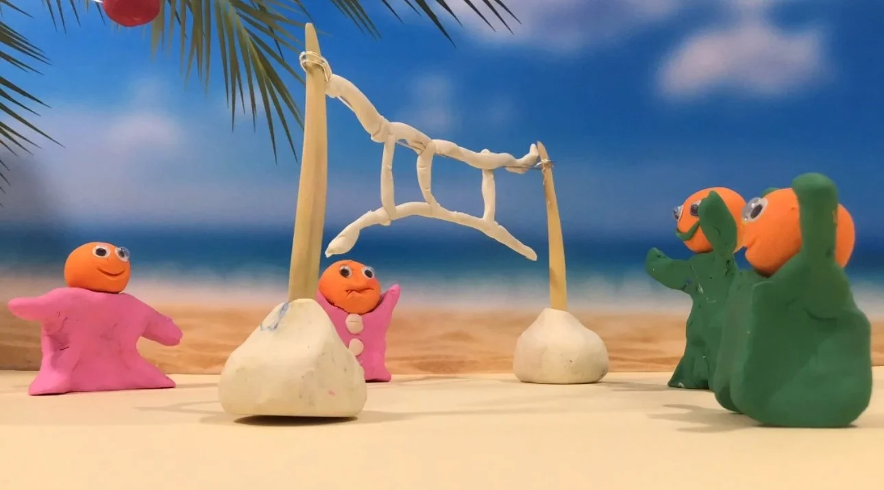 Clay characters on a beach scene with palm tree, ocean, and blue sky, resembling a stop-motion animation.