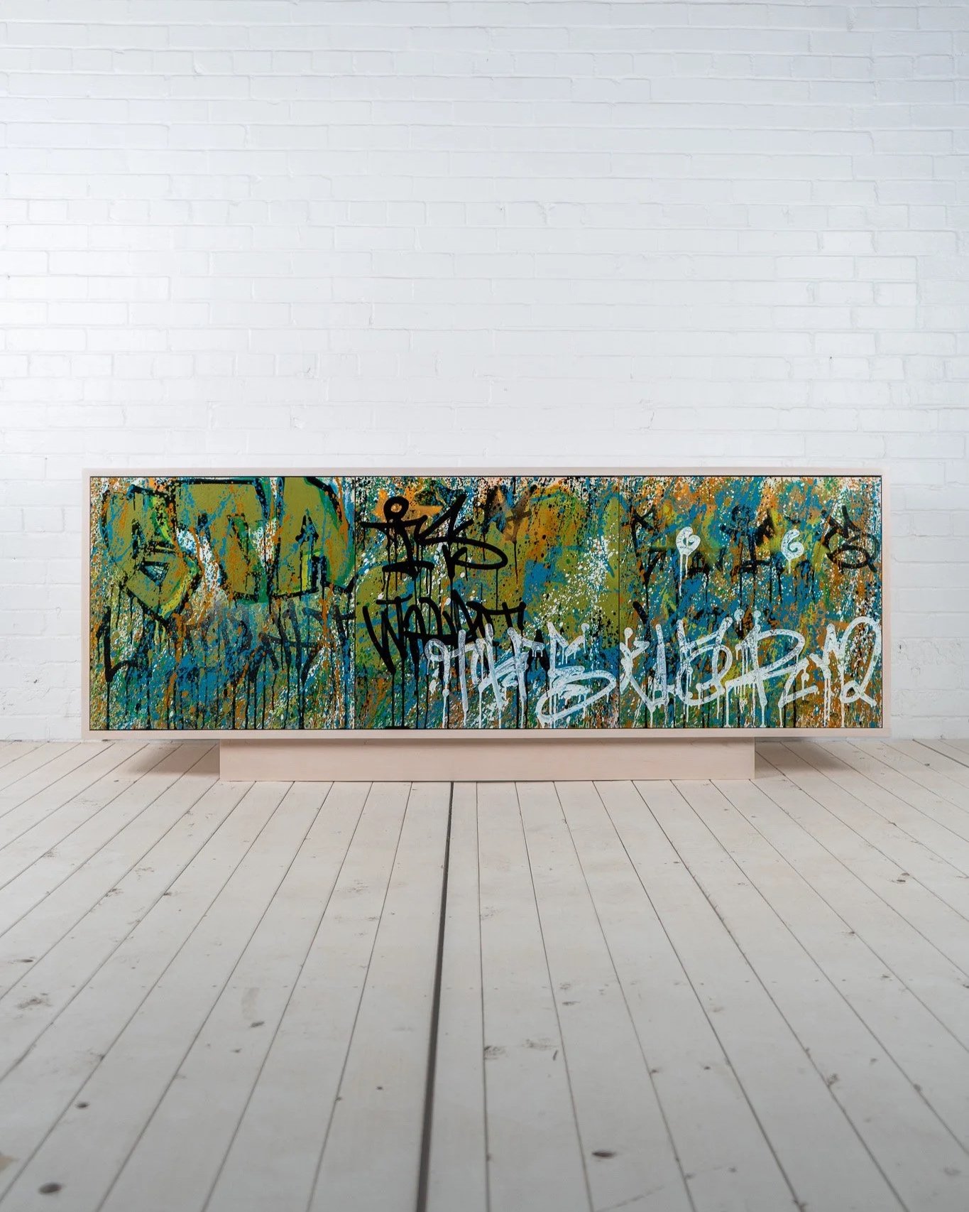 Solid hardwood cabinet with frosted white finish. Front of cabinet is “vandalized” with graffiti-style street art by local artist Duvall Winns. Cabinet is part of the larger “Vandalism Series” - a collaboration between Bricker & Beam and Duvall