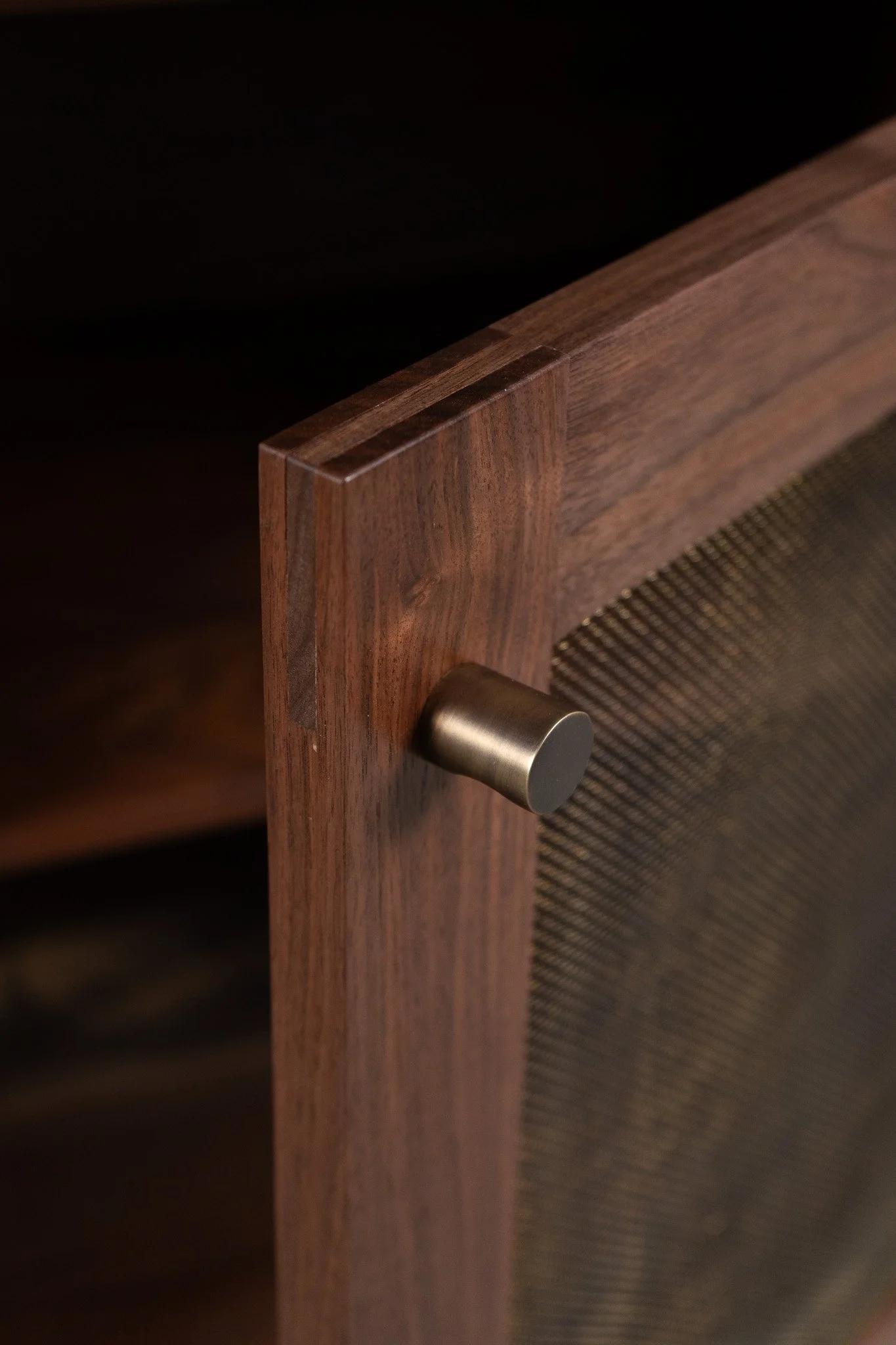 Close-up of a wooden speaker with a aged brass metallic knob