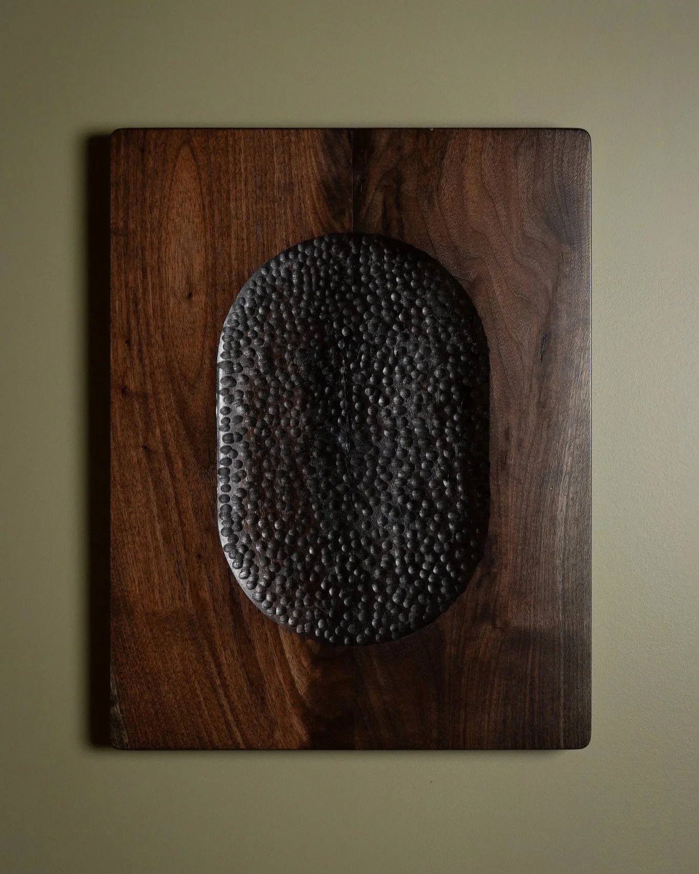 Hand carved sculptural wall art made from solid walnut with textured divots.