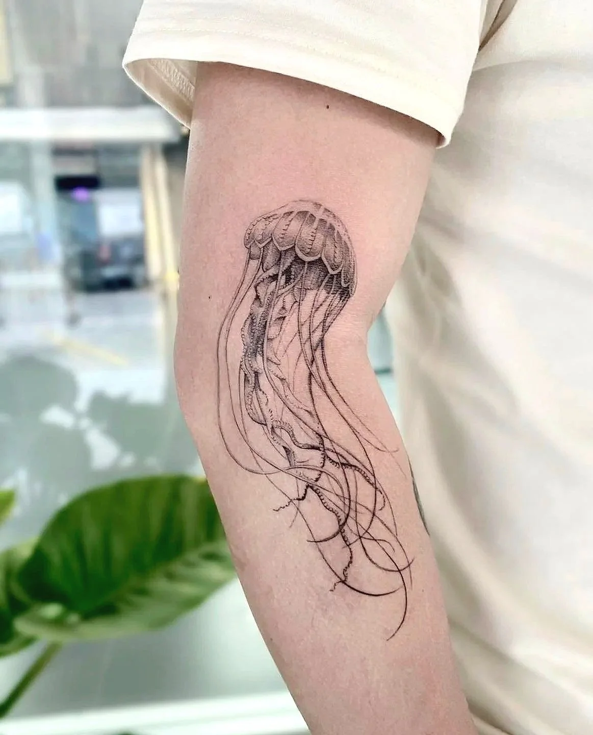 A tattoo of a jellyfish on a person's arm.